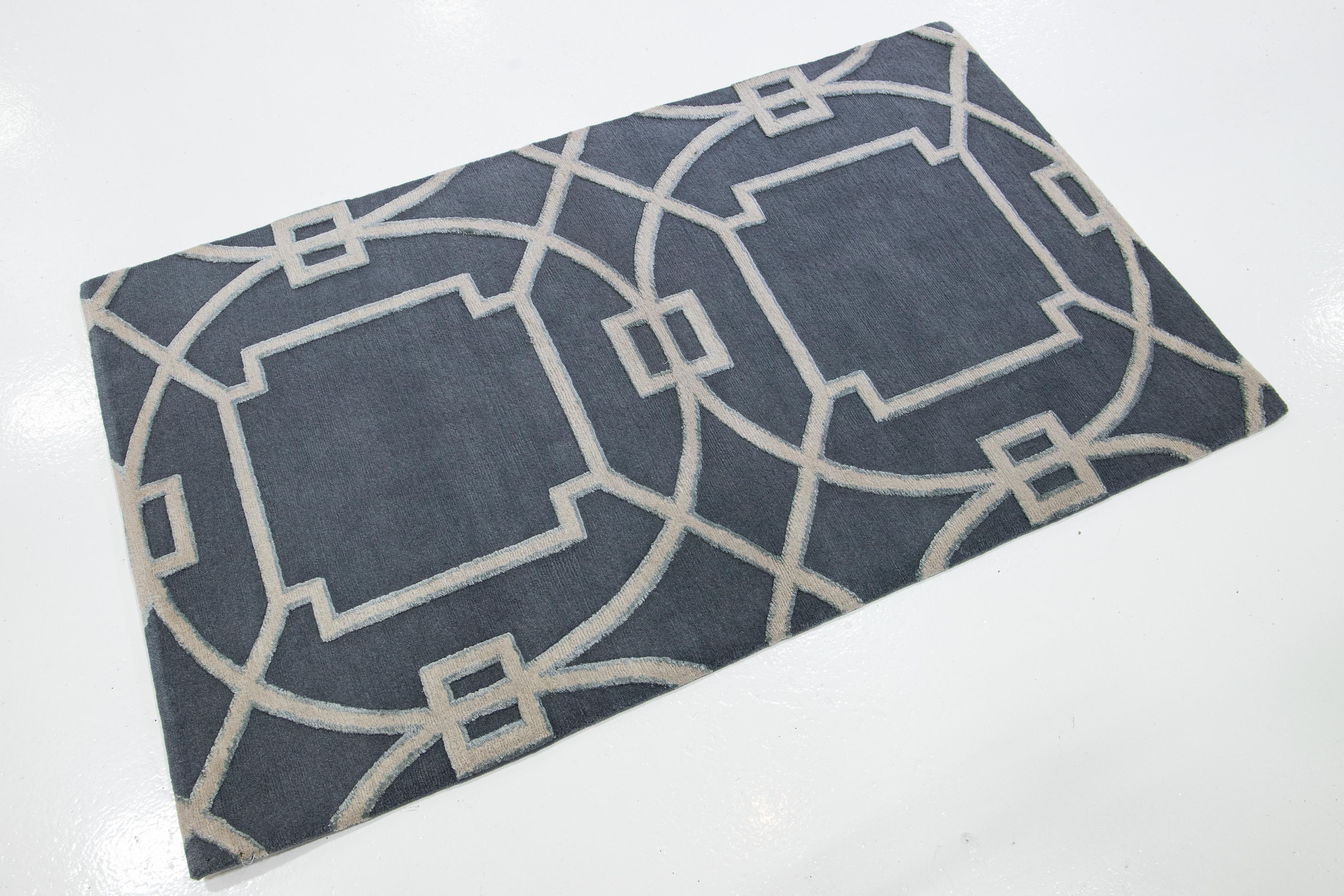 This custom rug features an Eastern-inspired blue field and gray geometric design. It is made with Tibetan wool and silk for an elegant and inviting look.

The price is based on an 8' x 10'.