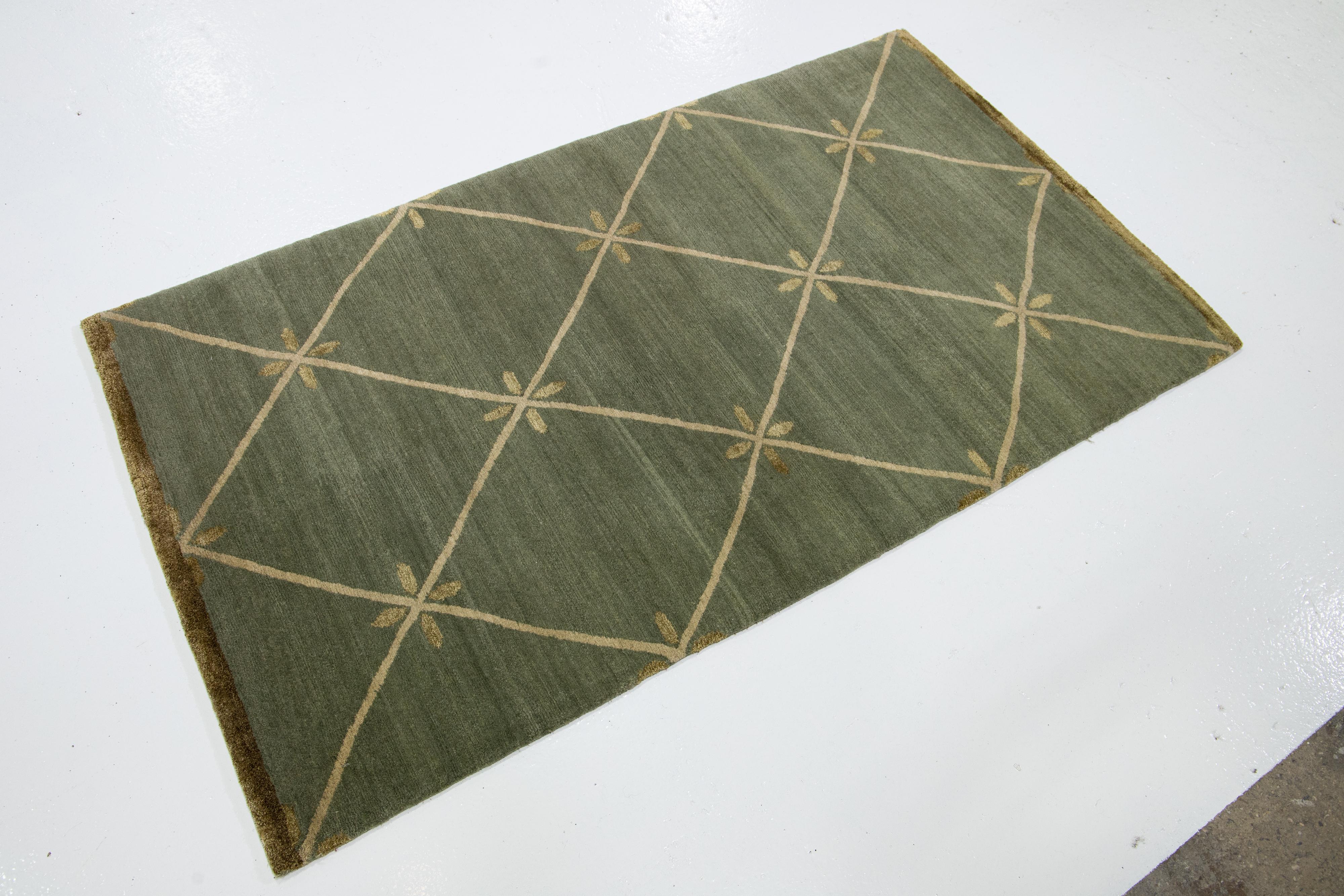 Questo tappeto personalizzato presenta un campo verde salvia con un disegno geometrico dorato. È realizzato in lana e seta tibetana per un design elegante e duraturo.

Il prezzo si basa su una superficie di 8' x 10'.