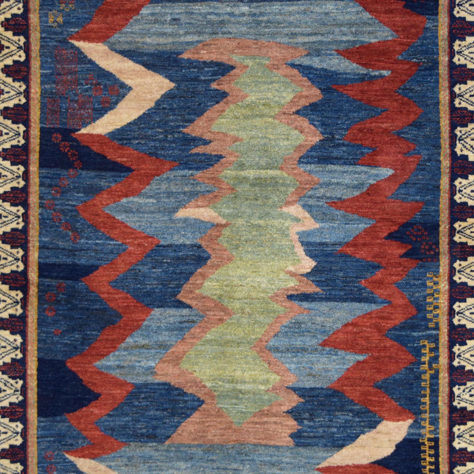 Ce tapis persan de transition en laine Orley Shabahang Qashqai mesure 4' x 6' et s'inspire de l'allure des motifs tribaux traditionnels de Qashqai. Le dessin représente un jardin de fleurs abstrait, traditionnellement appelé bagh en farsi.