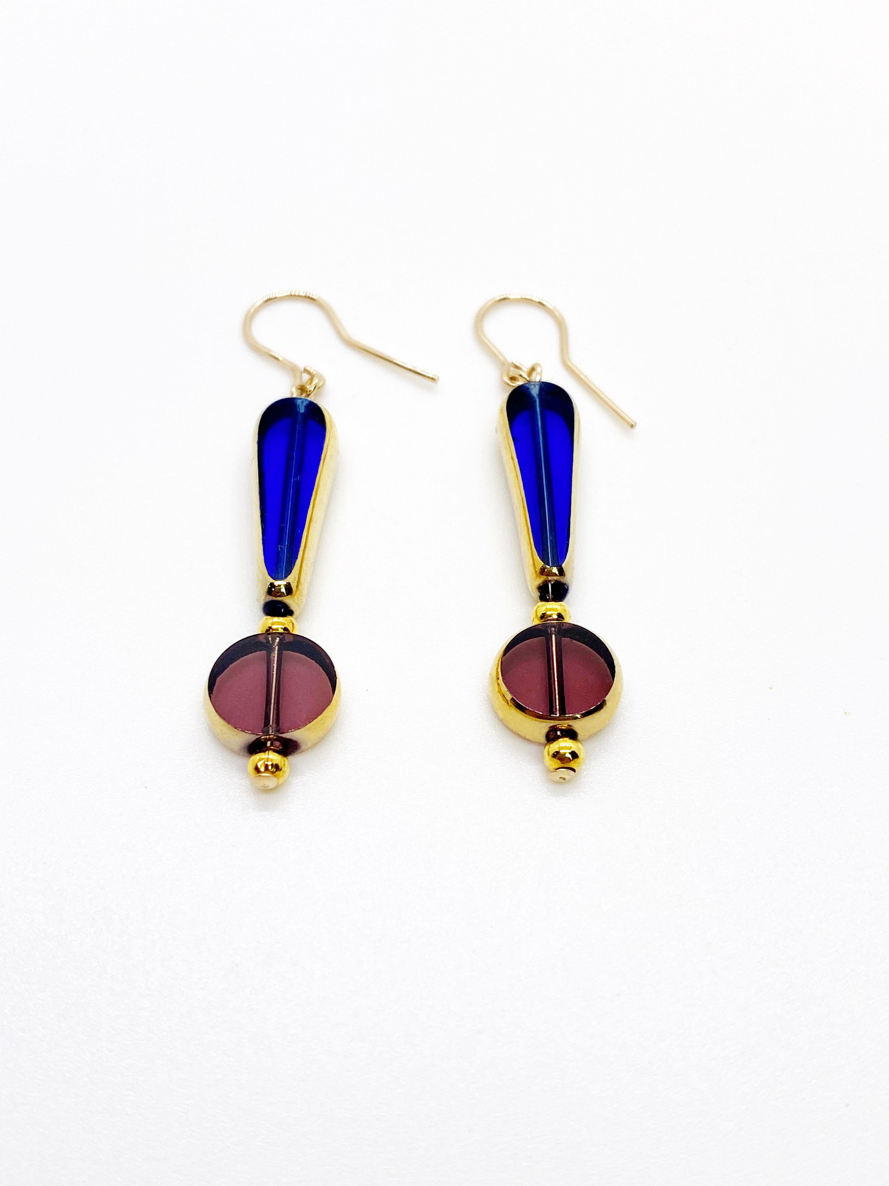 Each earring consist of 2 translucent German vintage glass beads that are framed with 24K gold with gold plated round beads. The earrings are finished with 14K gold-filled ear wires.

The vintage German glass beads were hand pressed during the
