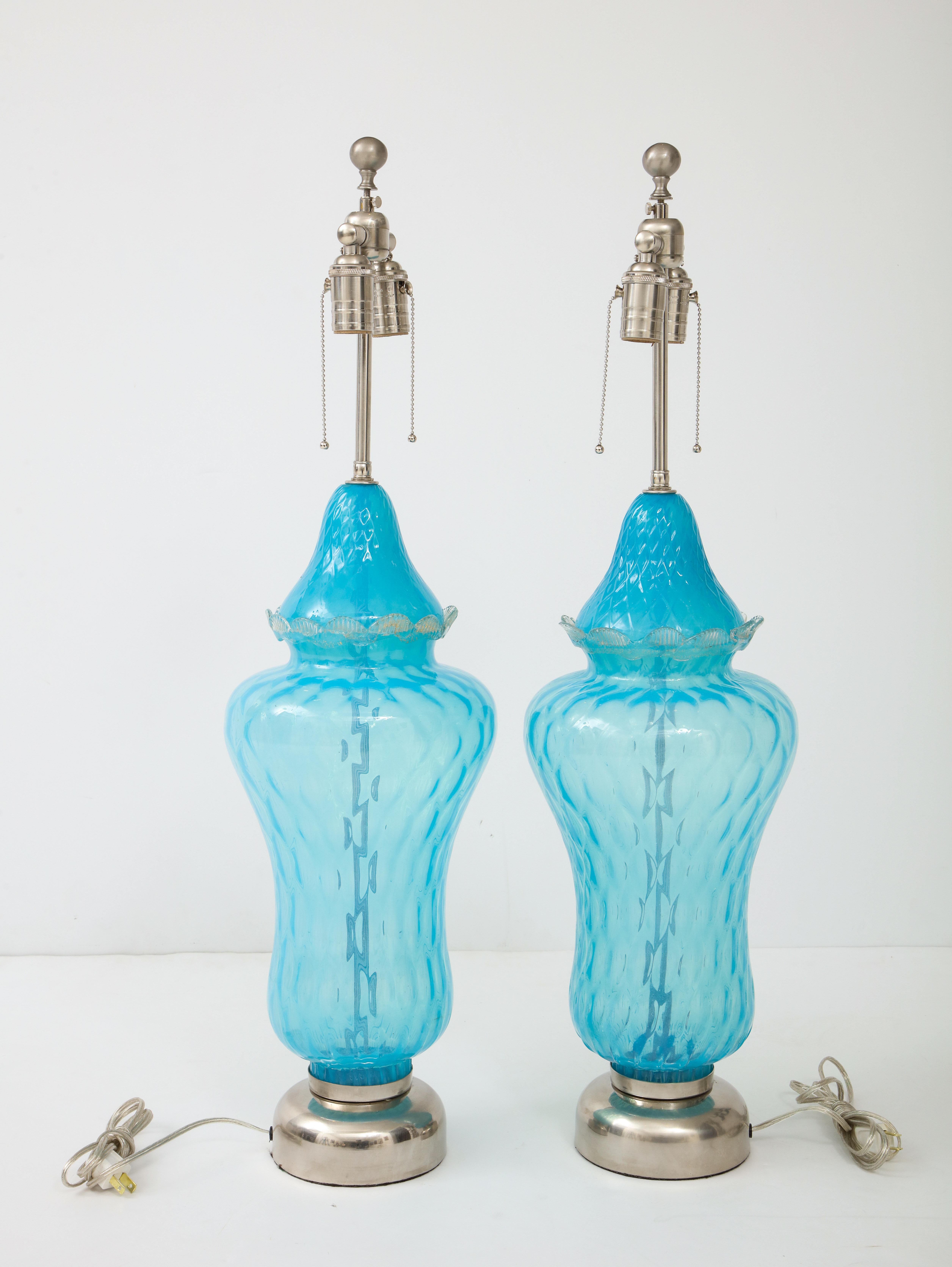 Pair of translucent sky blue Murano glass lamps with a slight all over quilted diamond pattern and a applied glass edge. Lamps sit on matte nickel bases and have been rewired for use in the USA. 100W max per socket. On display at 200 Lexington