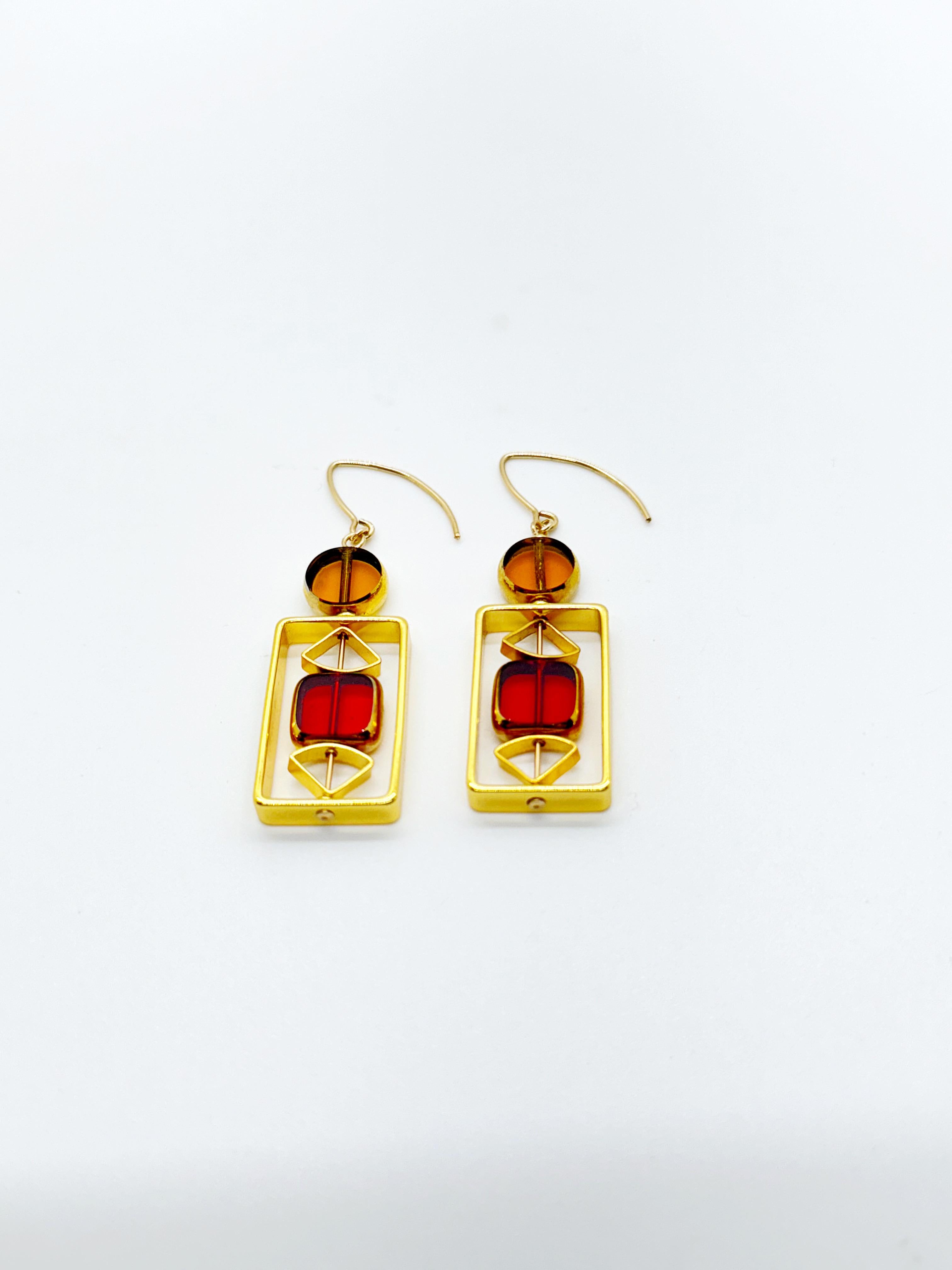 The earrings are lightweight and are made to rotate and reposition with movement.

The earrings are translucent yellow and red new old stock vintage German glass beads framed with 24K gold. The beads were hand-pressed during the 1920s-1960s in