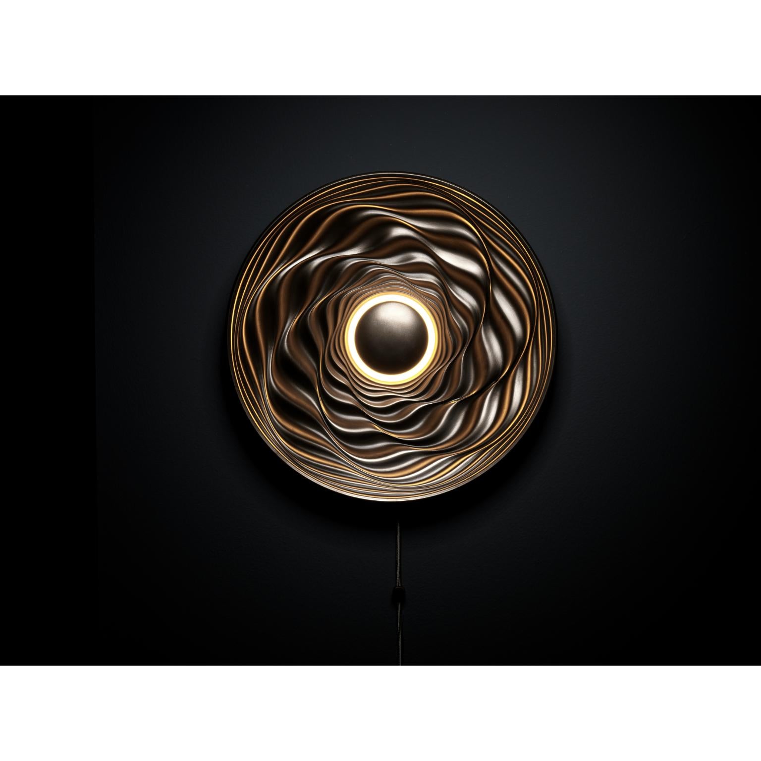 Transmission bronze sculpture by David Tragen 
Dimensions: W 42.5 x D 42.5 x H 8 cm
Materials: Cold cast bronze 

Transmission is an illuminated wall mounted sculpture which creates different effects depending on the use of its integral