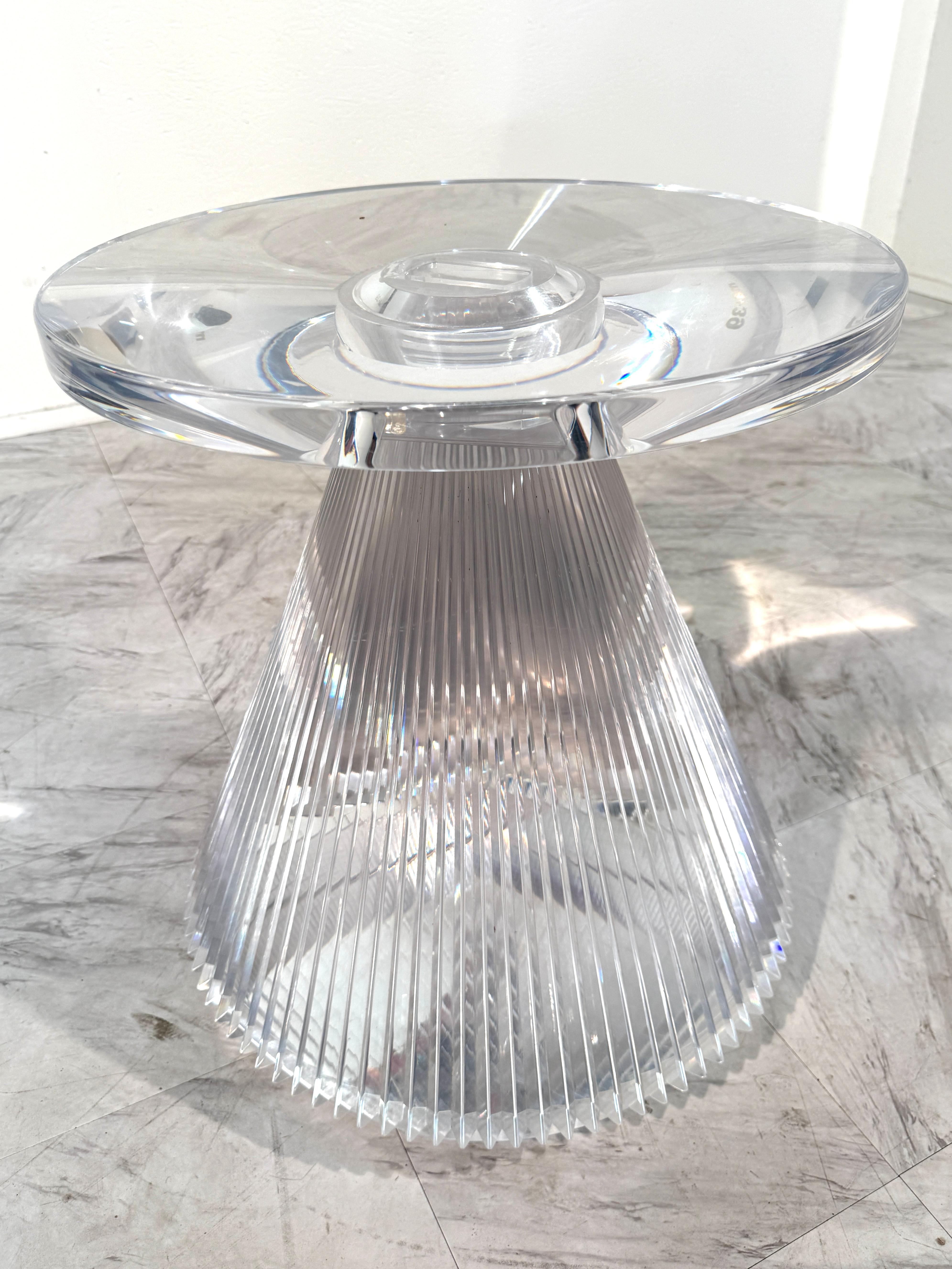 Table d'appoint contemporaine étonnante entièrement fabriquée en acrylique moulé transparent. Cette pièce de design italien présente une silhouette sculpturale avec un large plateau circulaire reposant sur une base conique cannelée. Les nervures