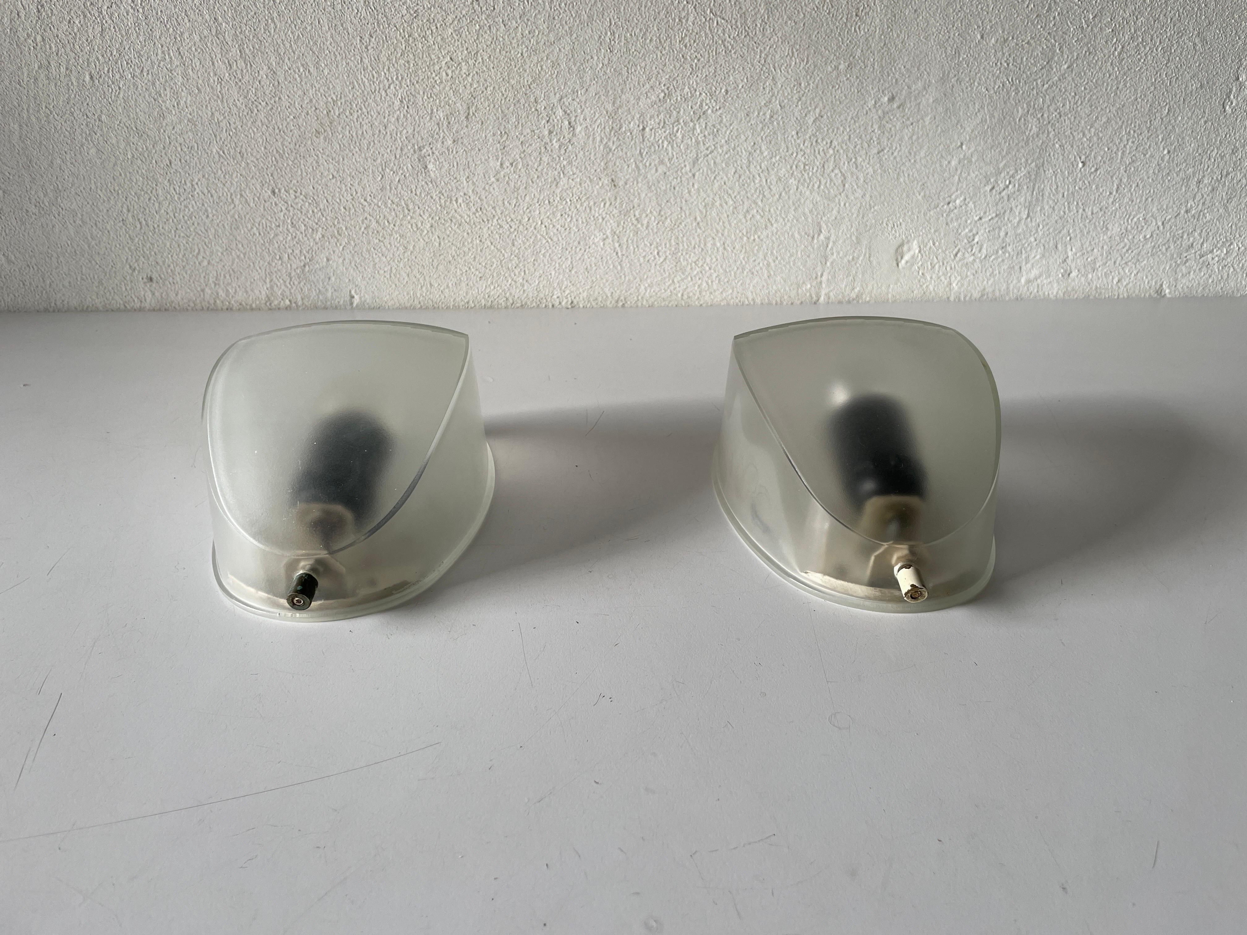 Transparent glass pair of sconces by Artemide, 1970s, Italy.

Very nice high quality wall lamps.

Lamps are in very good vintage condition.

These lamps works with E27 standard light bulbs. 
Wired and suitable to use in all countries.