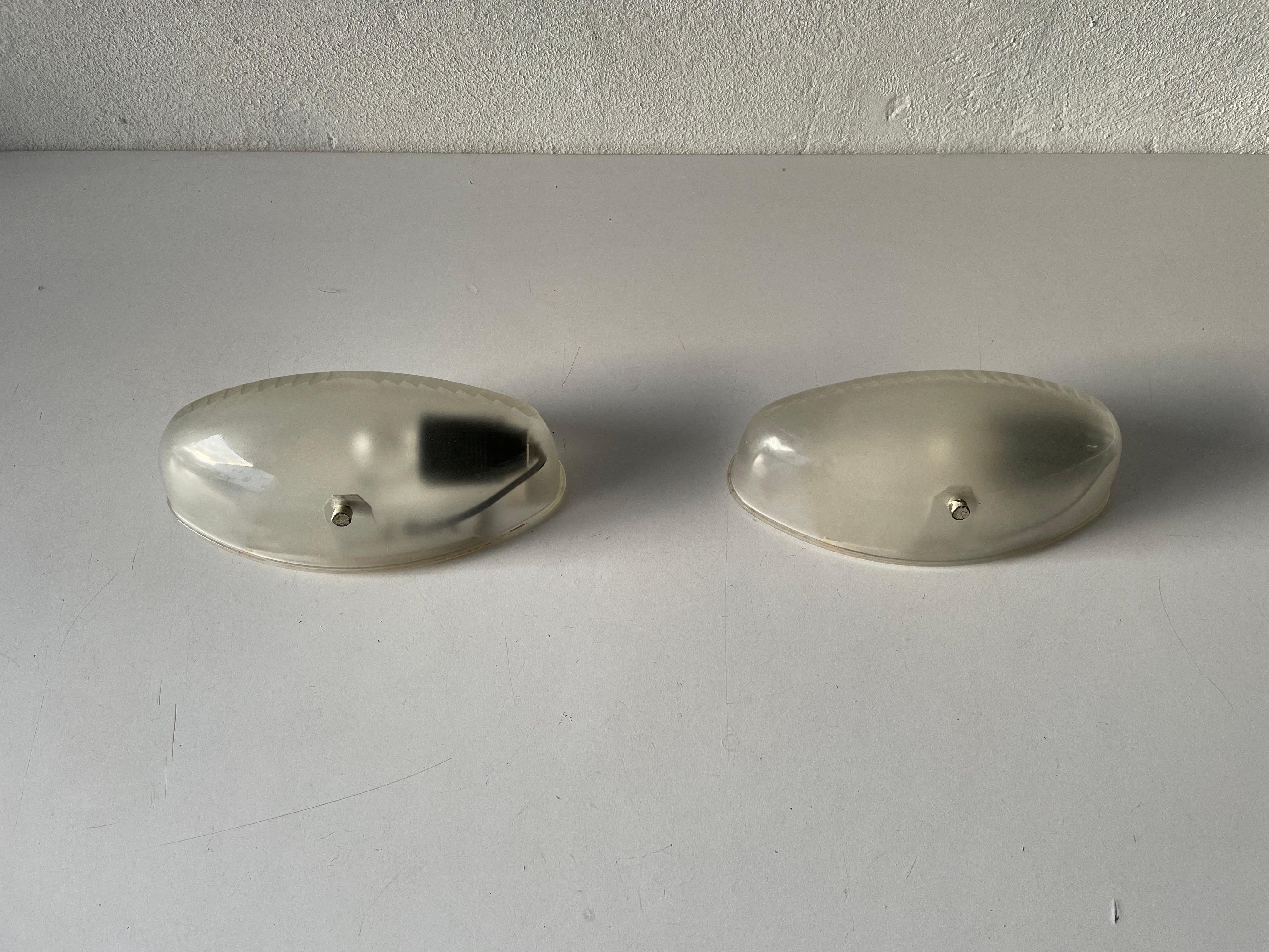 Transparent glass pair of sconces by Artemide, 1970s, Italy.

Very nice high quality wall lamps.

Lamps are in very good vintage condition.

These lamps works with E27 standard light bulbs. 
Wired and suitable to use in all countries. (110-220
