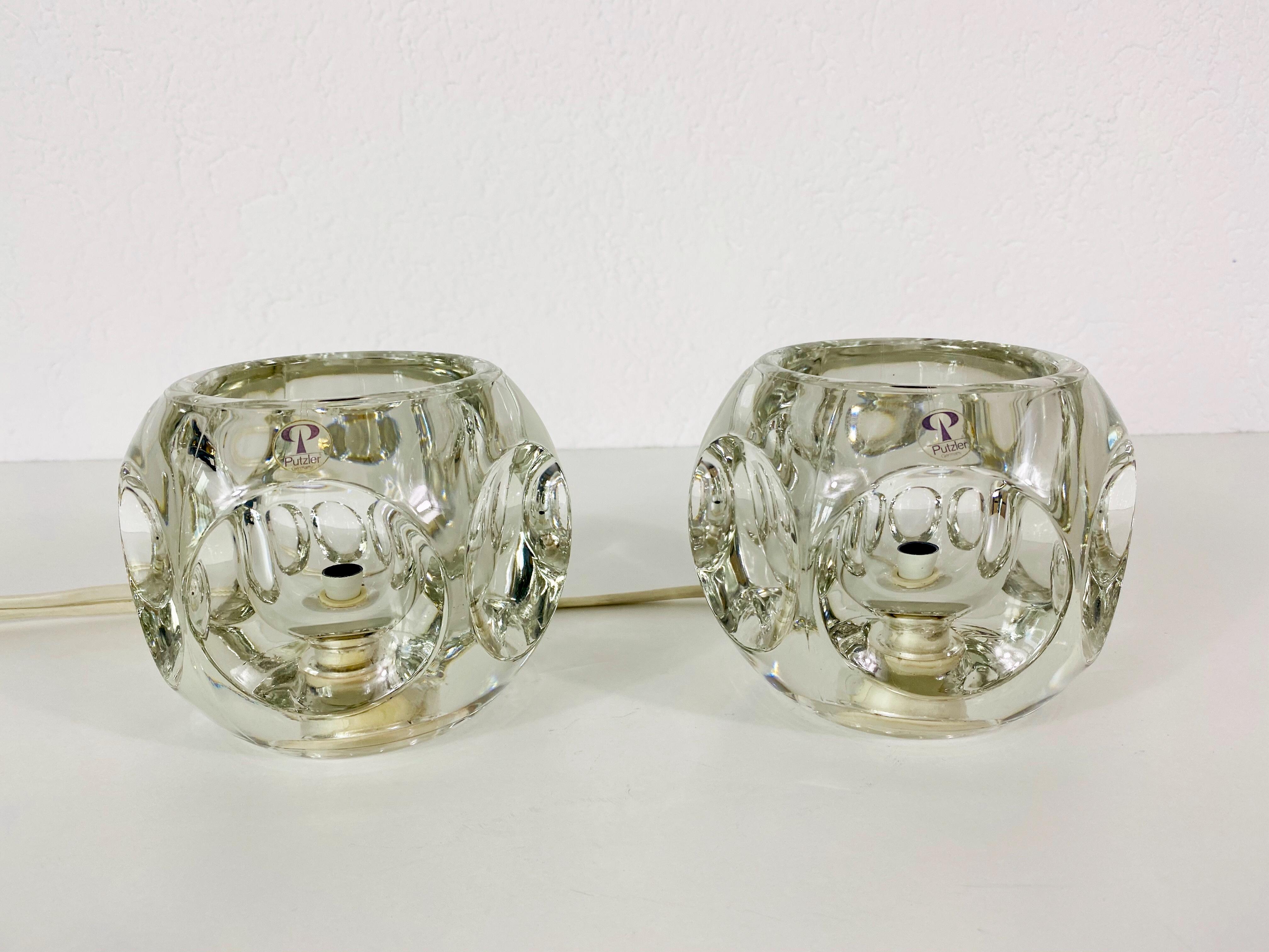 A beautiful pair of table lamps by Peill & Putzler made in Germany in the 1970s. They have a cube shape and are made of transparent ice glass. The original brand label is on both of the lights. They are in very good vintage condition.

The light