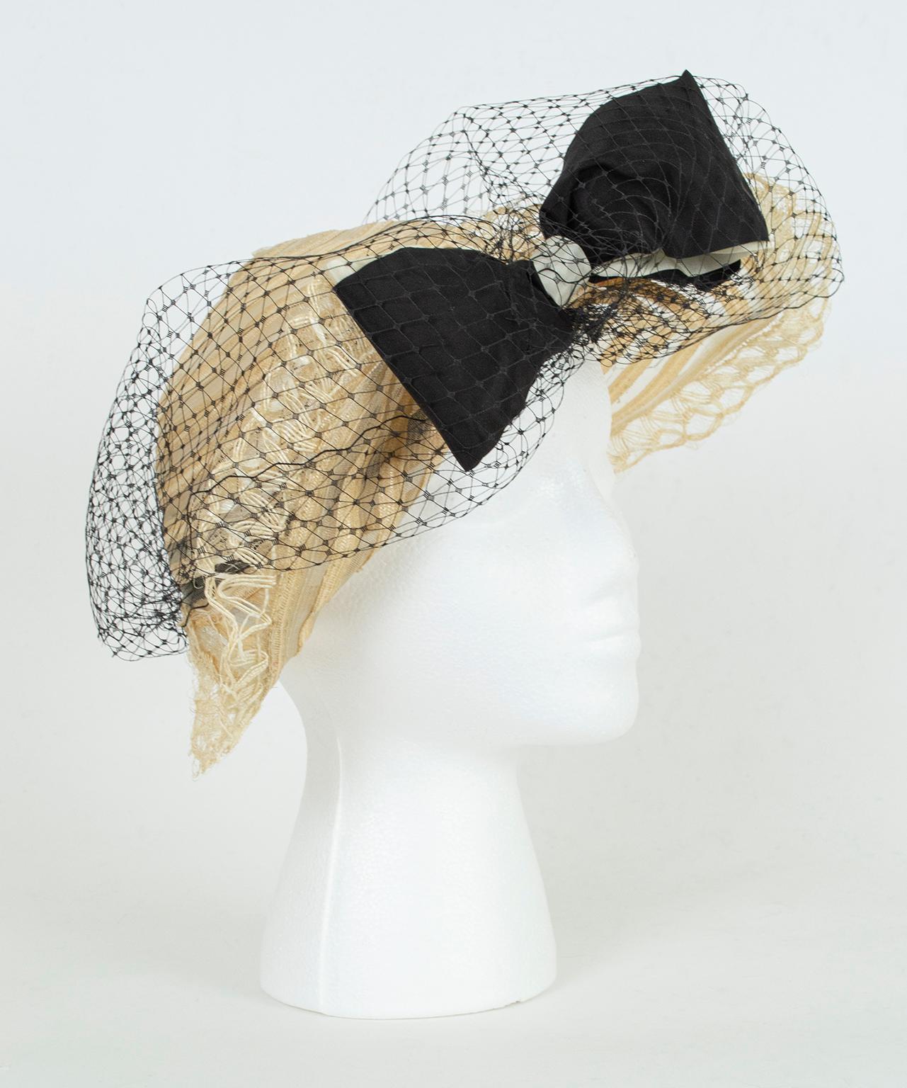 As feminine as it is clever, this diaphanous hat recalls to the one made famous by Mia Farrow on the official movie poster for 1974’s “The Great Gatsby” (pictured). Neither floppy nor structured, its half brim is pinned at the center front by an