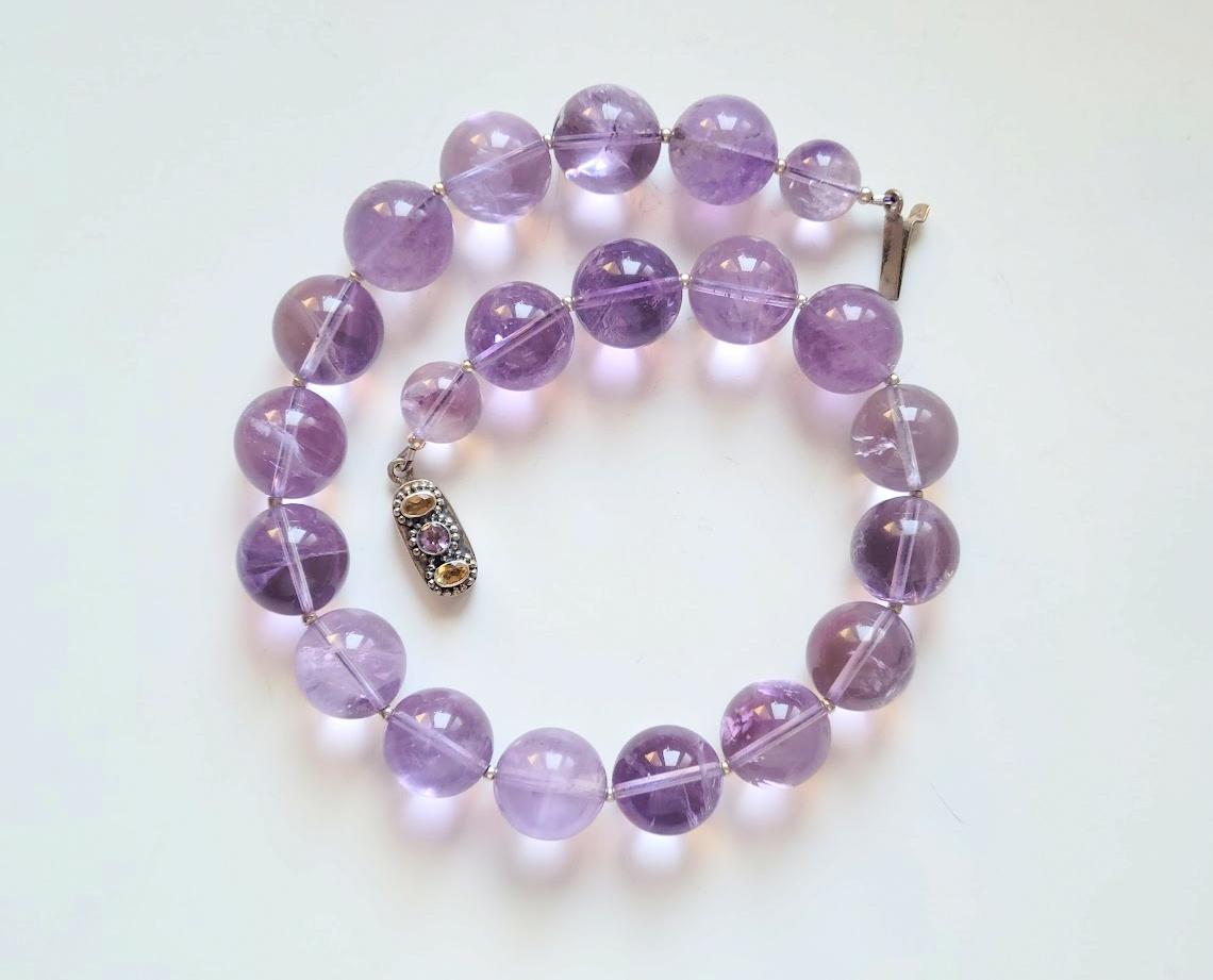 The necklace is 19 inches (48 cm) long, and the smooth round beads are 20 mm in size. Two beads near the clasp are 15mm in diameter.
The amethyst beads are transparent, with light inclusions that confirm the naturalness of the amethyst. The color is