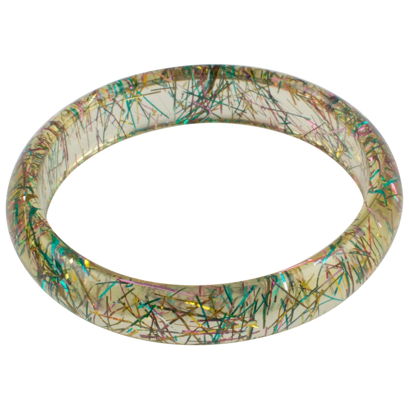 This lovely Lucite bracelet bangle has a domed shape and is comprised of transparent Lucite, injected with metallic thread inclusions in multicolor tones. The metallic threads sparkle as those of Christmas tinsels. There is no visible maker's