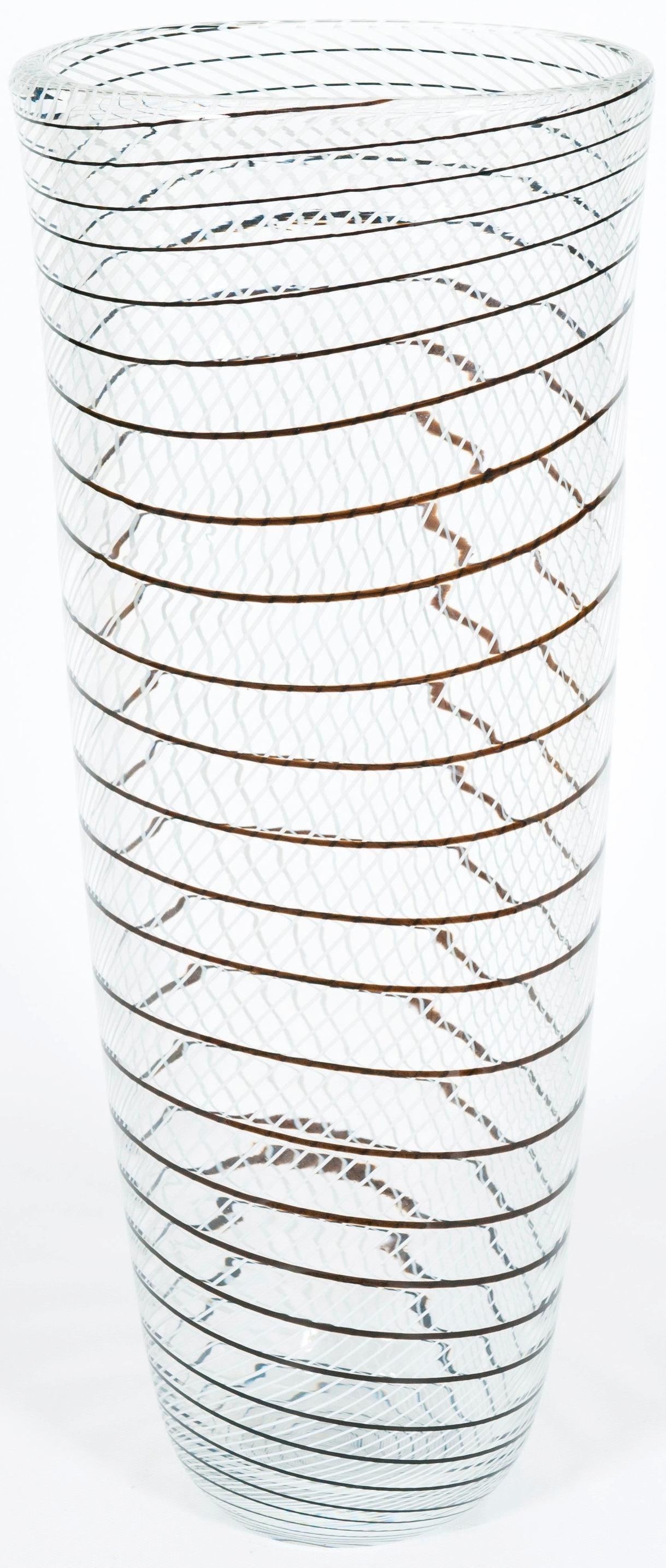 Transparent Murano glass artistic vase with black and white patterns, 1990s.
This artistic vase is a unique and special object, perfect for a refined Murano glass lover. Its shape is oval, and developed in in height which is 23.6