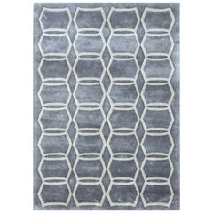 Tappeto di seta moderno e geometrico TRAPEZA, colore grigio taupe, realizzato a mano.