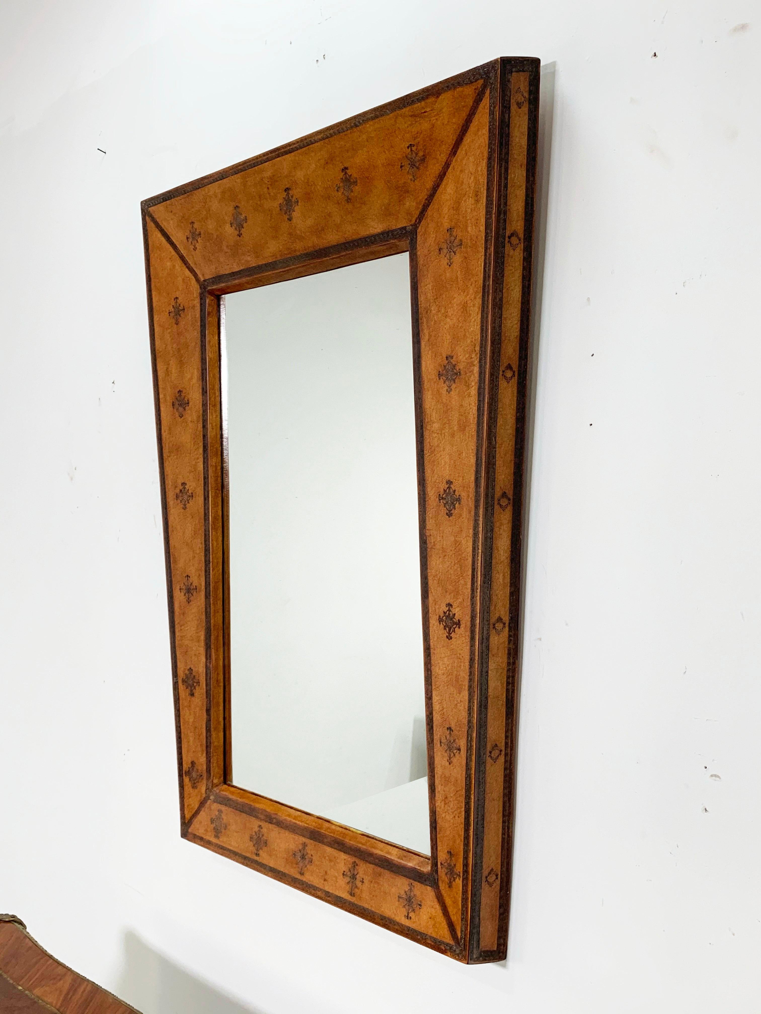 An elegant oversized trapezoidal wall mirror in tooled leather, circa 1970s.