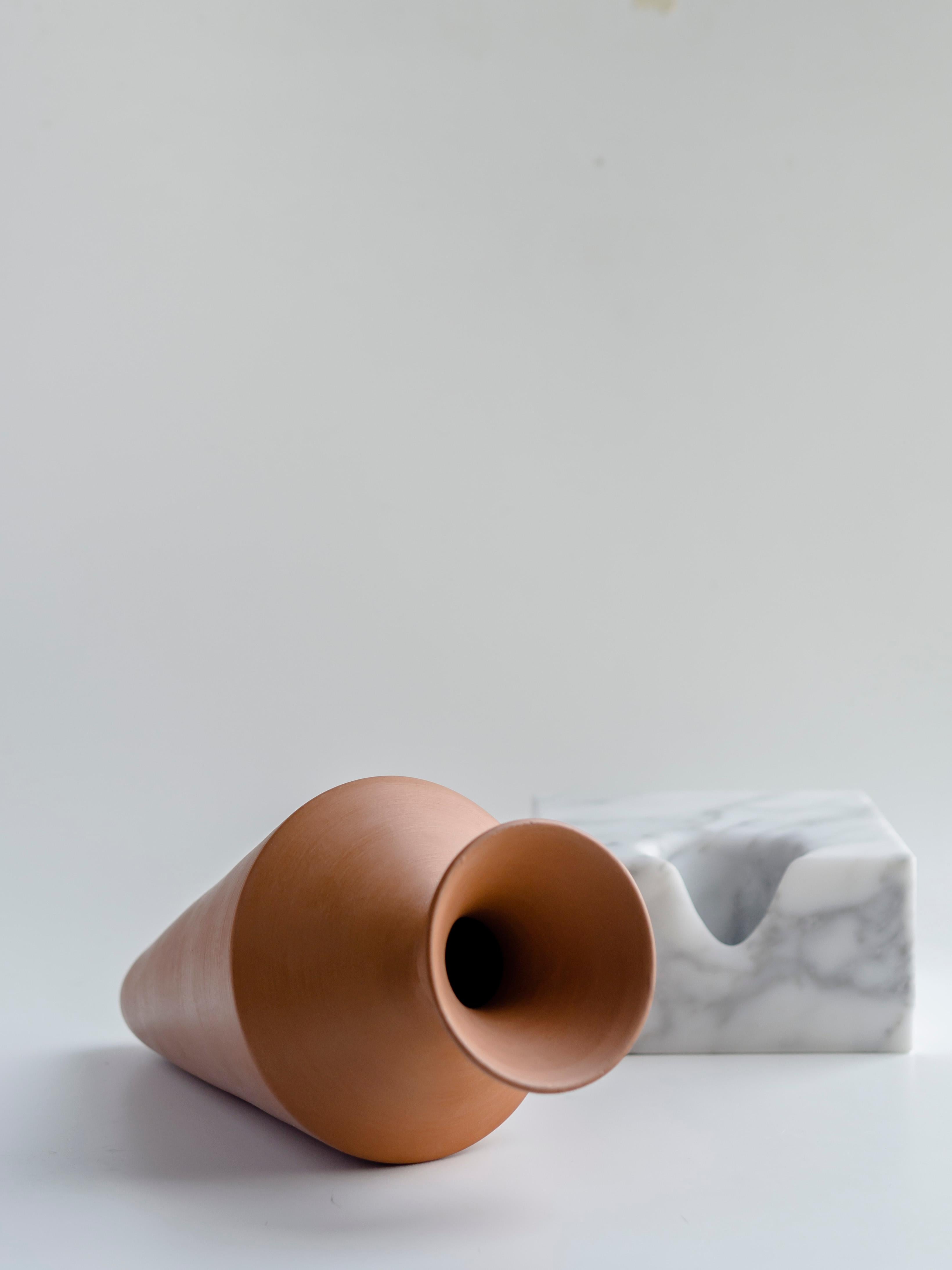 Natural ceramic grafted and balanced vases in white Carrara marble elements recount experiences, daily life, moments; the solidity of the bases is deformed to accommodate the fragile containers of a continuous and material exchange of sensations.