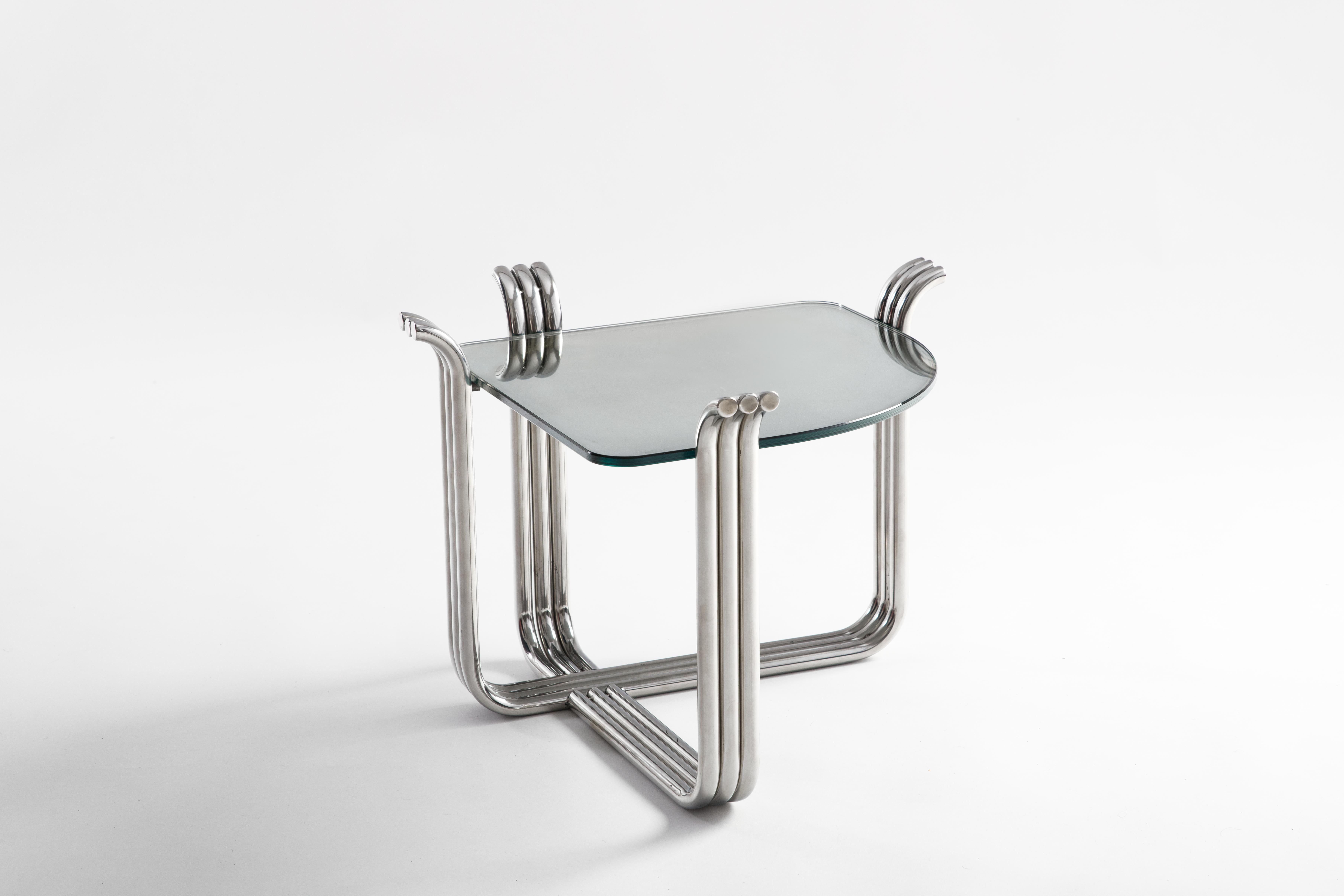 Traspade side table by Testatonda
Dimensions: D 55 x W 55 x H 42 cm.
Materials: stainless steel, glass.

The Trespade collection is the repetition of dimensions, the intertwining of materials, colors and reflections: our way of interpreting the