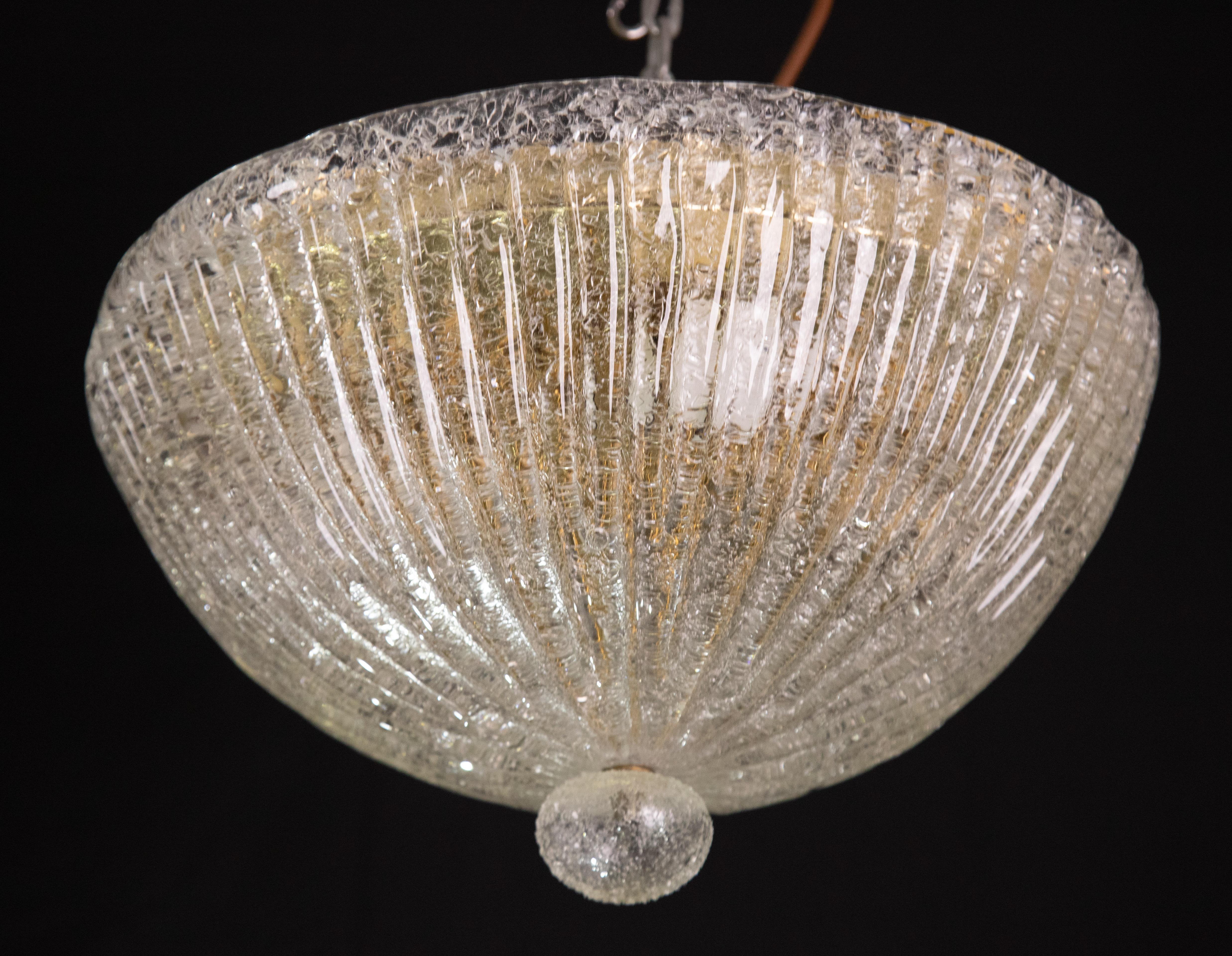 Stunning transparent/gold Murano ceiling light.
The ceiling light consists of two glass elements, the central plate plus the trasparent element low.
The central plate is surrounded by a wavy stripe typical of Venetian\Murano workmanship.
The ceiling