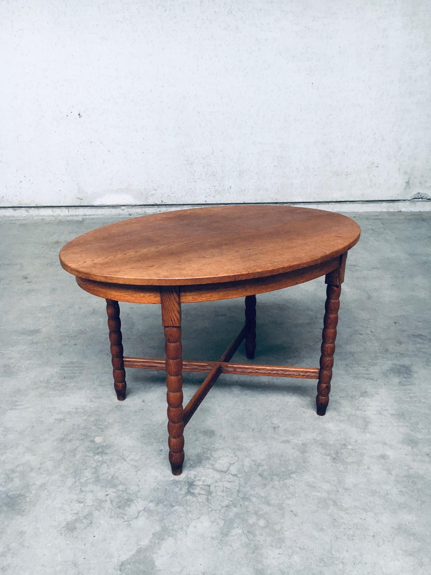 Tavolo da centro ovale rustico vintage Travail Populaire Oak. Realizzato in Francia, periodo degli anni '40. Tavolo centrale in rovere massiccio con gambe a rocchetto e collegamento trasversale. Tavolo di forma ovale di buona fattura che di solito
