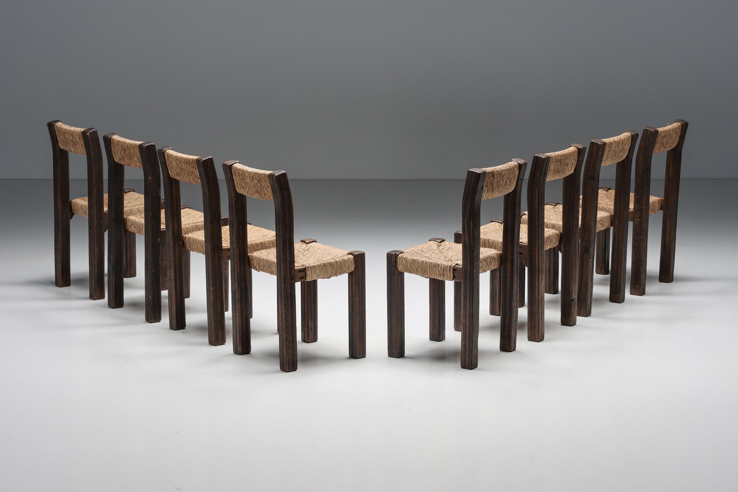 Set of 8 French dining chairs with straw seating, a remarkable example of raw elegance and craftsmanship. The imperfect, wabi-sabi wooden structure adds a touch of rustic charm, making these chairs a remarkable example of French artistry. Perfectly