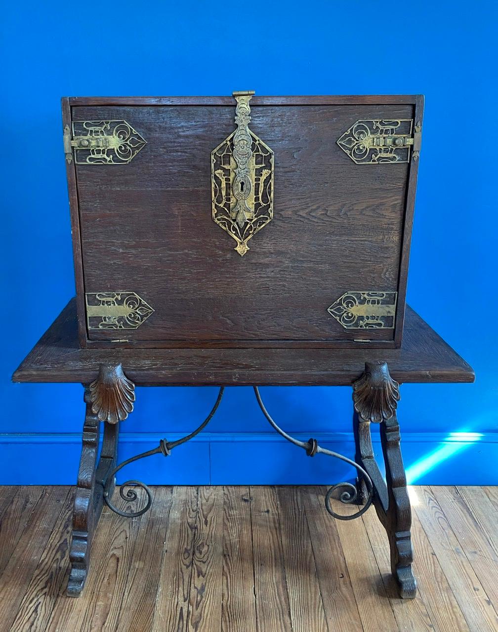 The Bargueno is a portable desk. The base is typically Spanish and dates from 20th Century. The upper part was added in the 20th century in England and dates from the Arts and Craft movement. A movement recognizable in its different