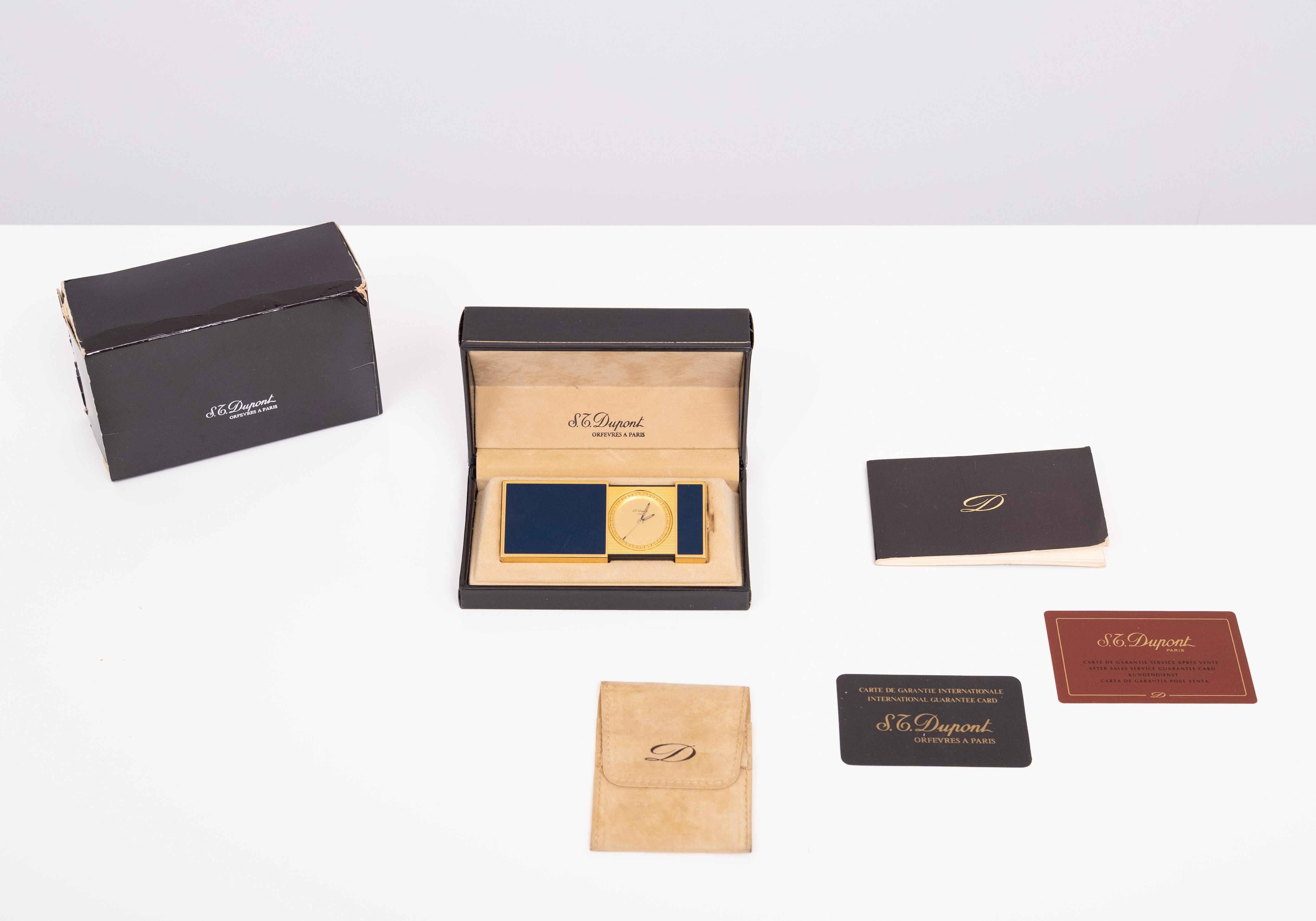 Small travel alarm clock with alarm bell, signed ST Dupont.  Blue Chinese lacquer. In excellent condition overall, already used and working perfectly. Dimensions closed: 63 x 37 x 12 mm Open: 95 mm
service rapport included , comes with the 2