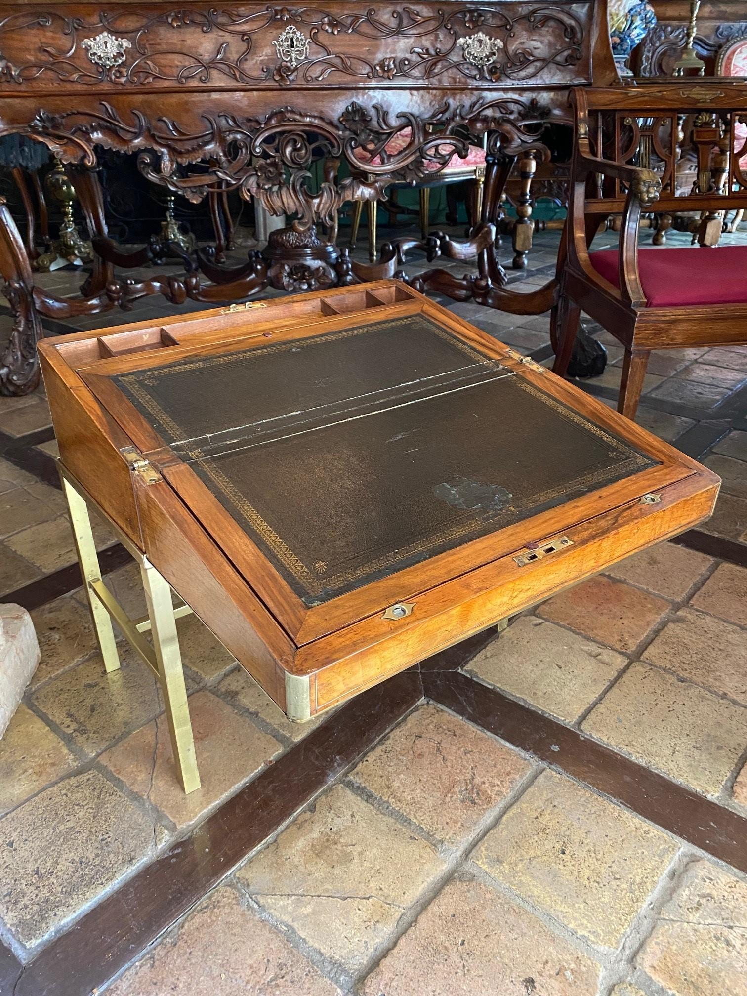 Exquisite English lap traveling desk portable. Countryside writing bureau in good condition considering the usage of the period in quality warm walnut wood. Rising on a later brass stand when not in use, fitted with Secret compartment and drawers