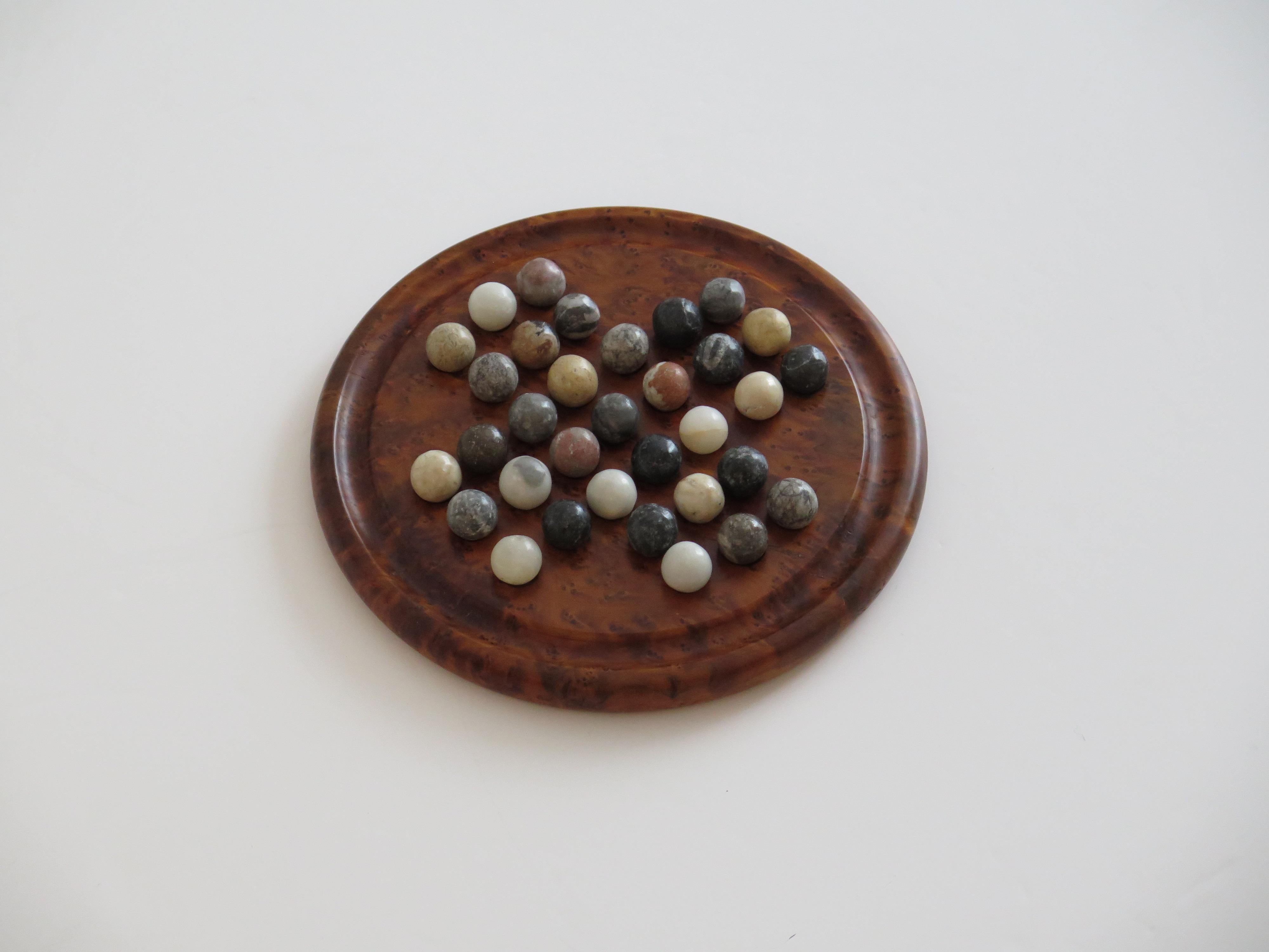 This is a very good and complete board game of Marble Solitaire,with a hand turned hardwood board and 33 agate stone marbles, which we date to the Art Deco period of the 20th Century, Circa 1925.

The circular turned board is very attractive being
