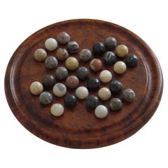 Game solitaire avec planche de bois dur et 33 marbres de pierre d'agate, vers 1925