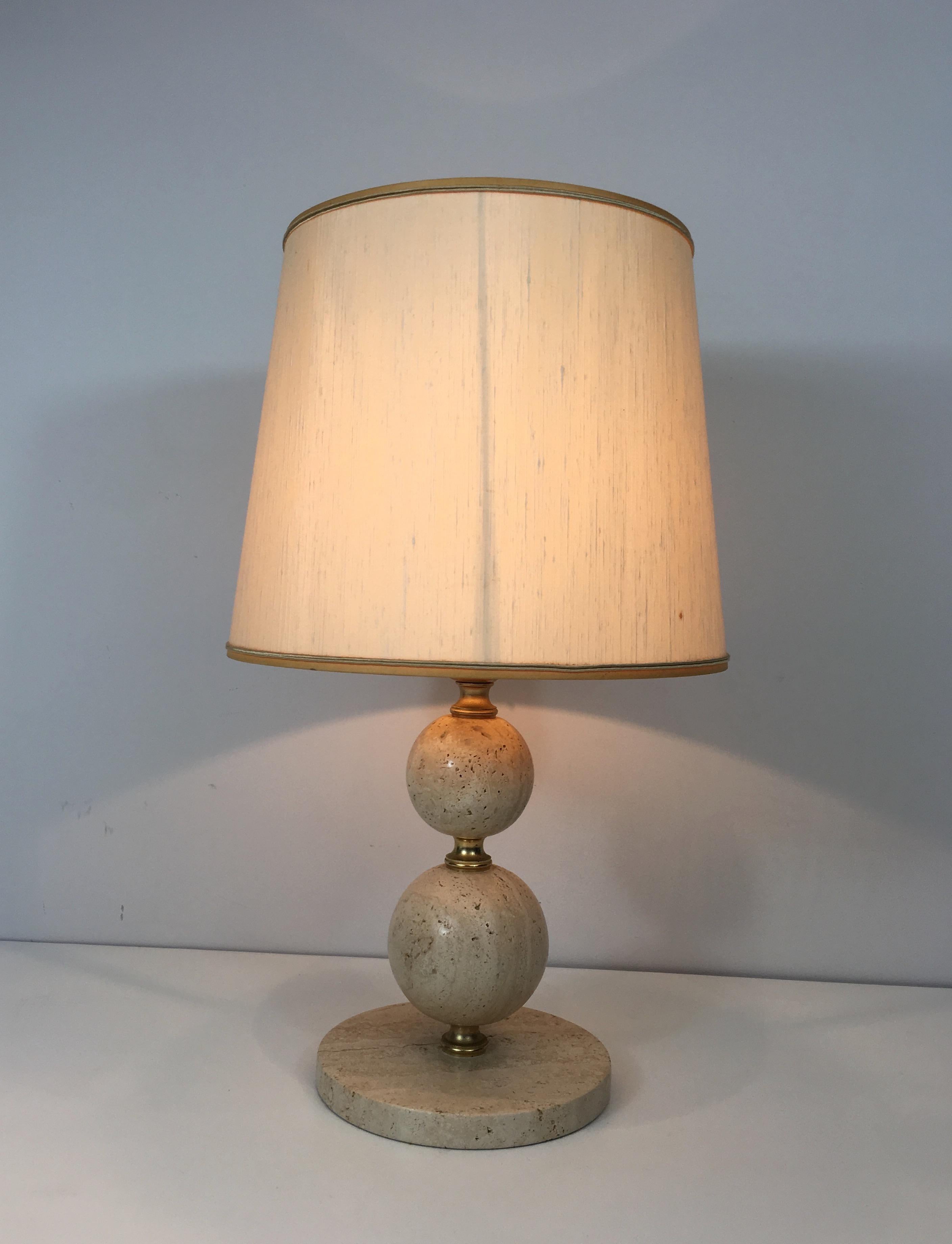 This nice table lamp is made of travertine and brass. This is a French work. Circa 1970.