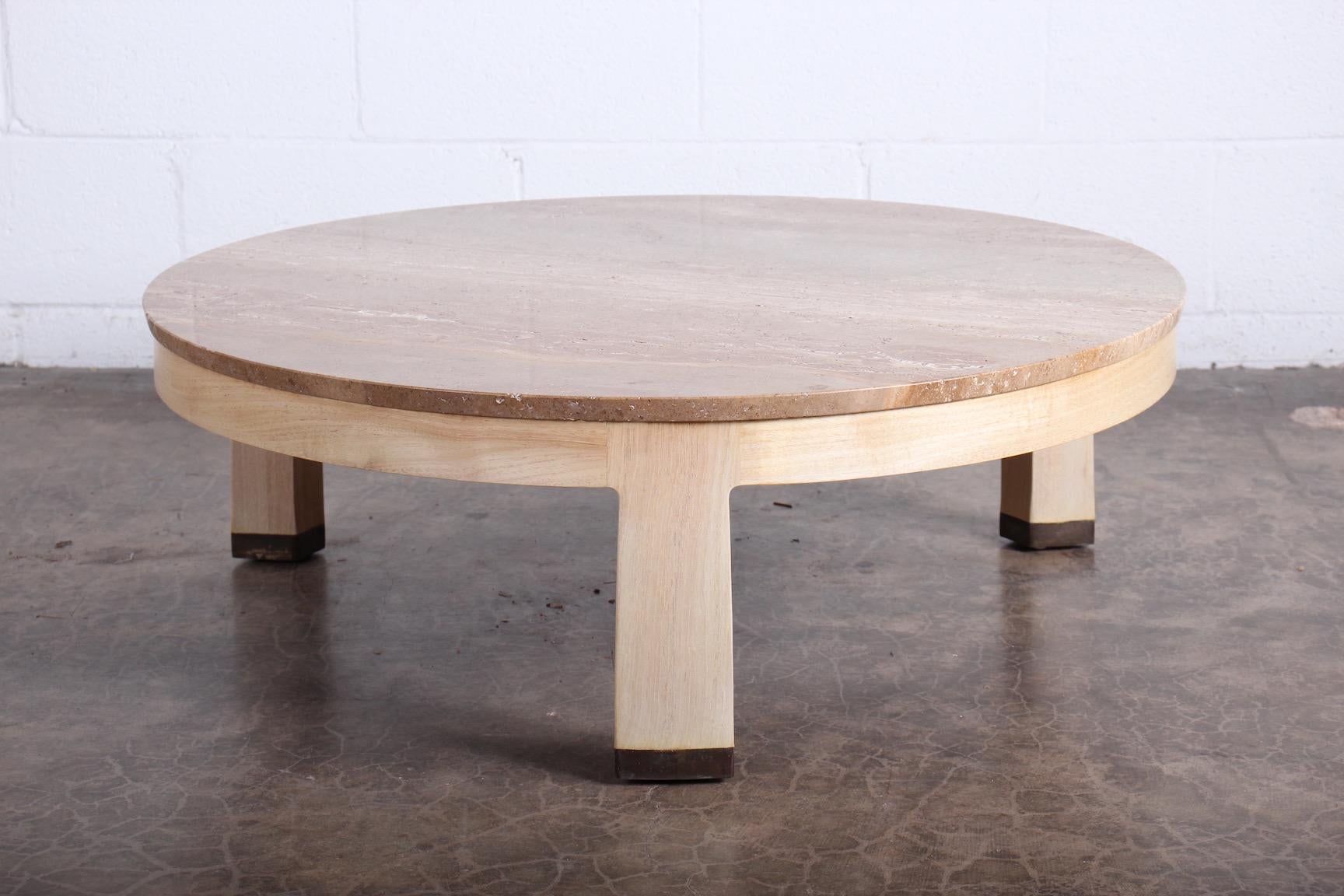 A bleached mahogany table with travertine top and brass feet. Designed by Edward Wormley for Dunbar.