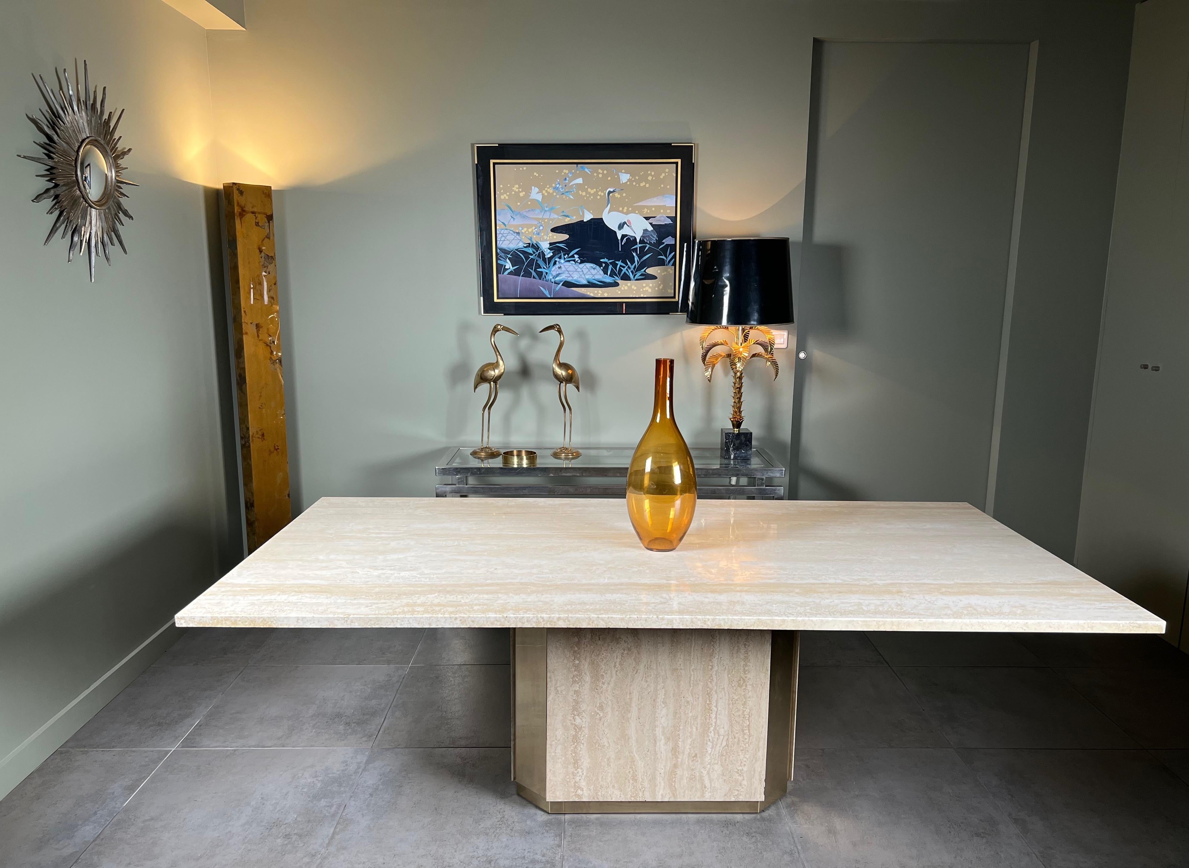 This amazing dining room table is made up of an octagonal base in travertine and brass plates and a thick travertine top. This table can accommodate 10 people. This is a Unique piece. French work. Circa 1970