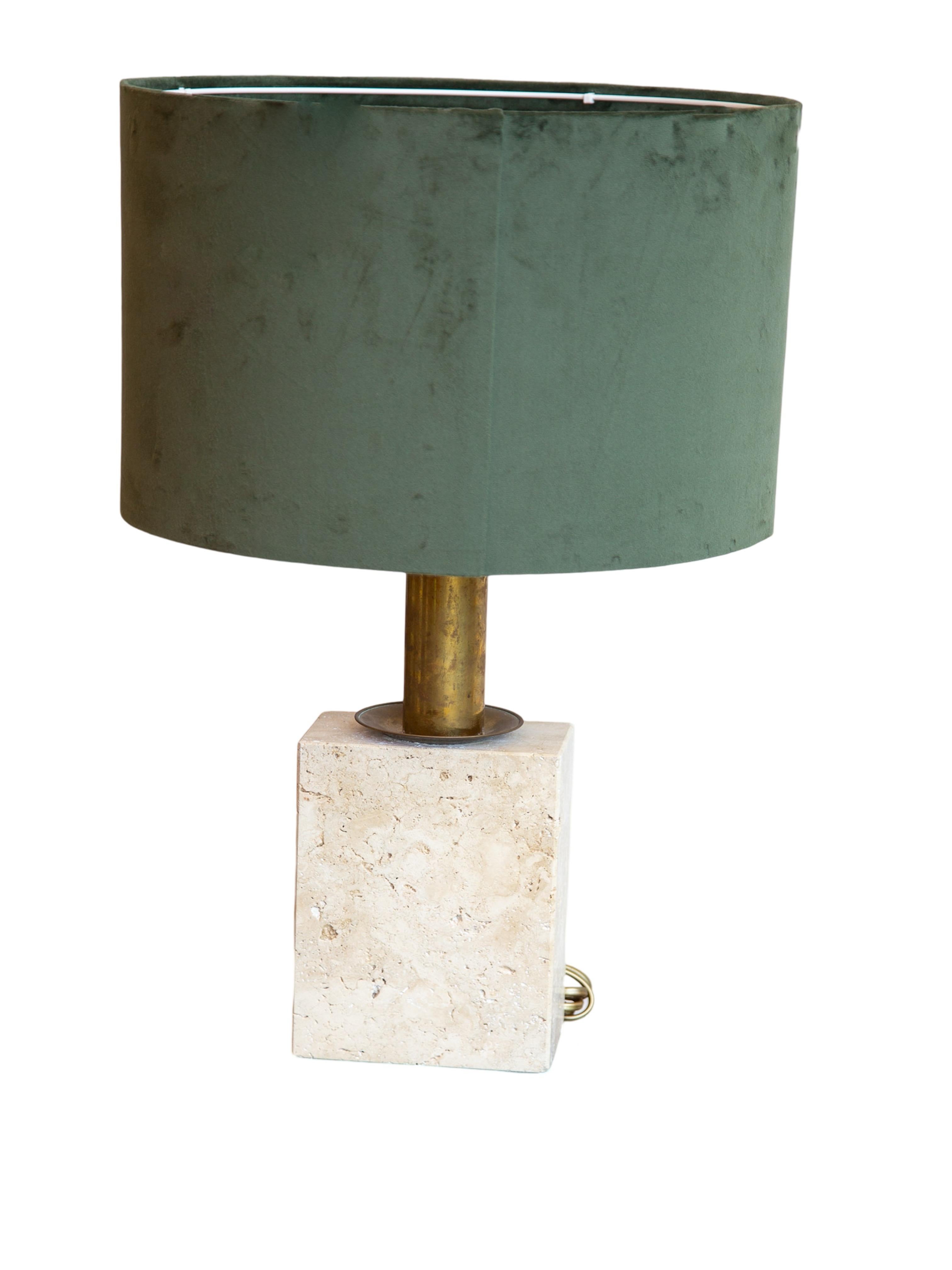 Con una pantalla de tambor de terciopelo verde intenso, un cálido vástago acabado en latón y una distintiva base de piedra travertino grabada con sutiles acentos lineales, esta lámpara aporta textura y elegancia a cualquier espacio. Perfecto para