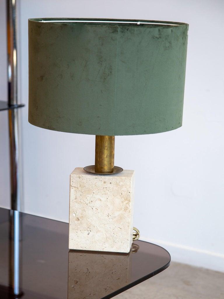 Mit ihrem tiefgrünen Trommelschirm aus Samt, dem warmen, messingfarbenen Stiel und dem unverwechselbaren Sockel aus Travertinstein mit subtilen, linearen Akzenten bringt diese Lampe Struktur und Eleganz in jeden Raum. Sie eignet sich perfekt für