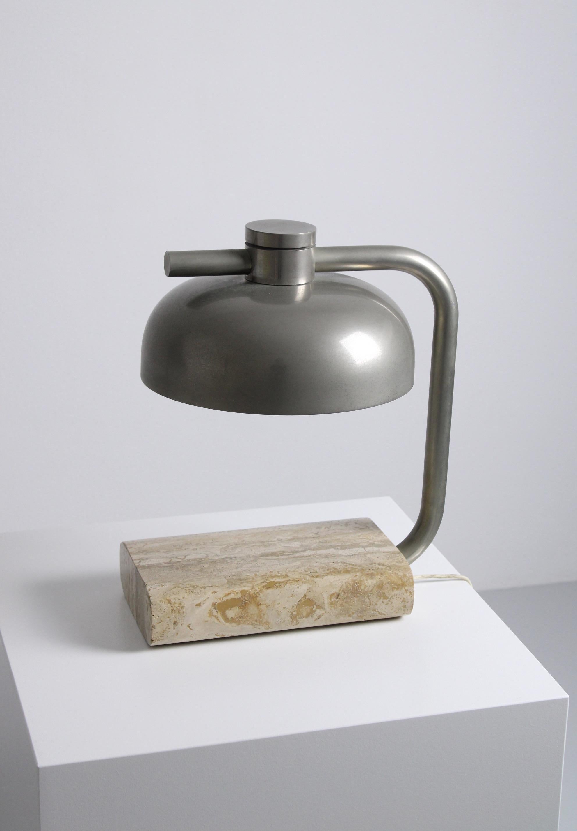 Rare table lamp by Paolo Salvi, made in Italy in the 1970s. It’s made of travertine, which is a common natural stone in Italy. The stem of the lamp goes up and holds a round shade made of chrome-plated metal which is adjustable. The mix of these