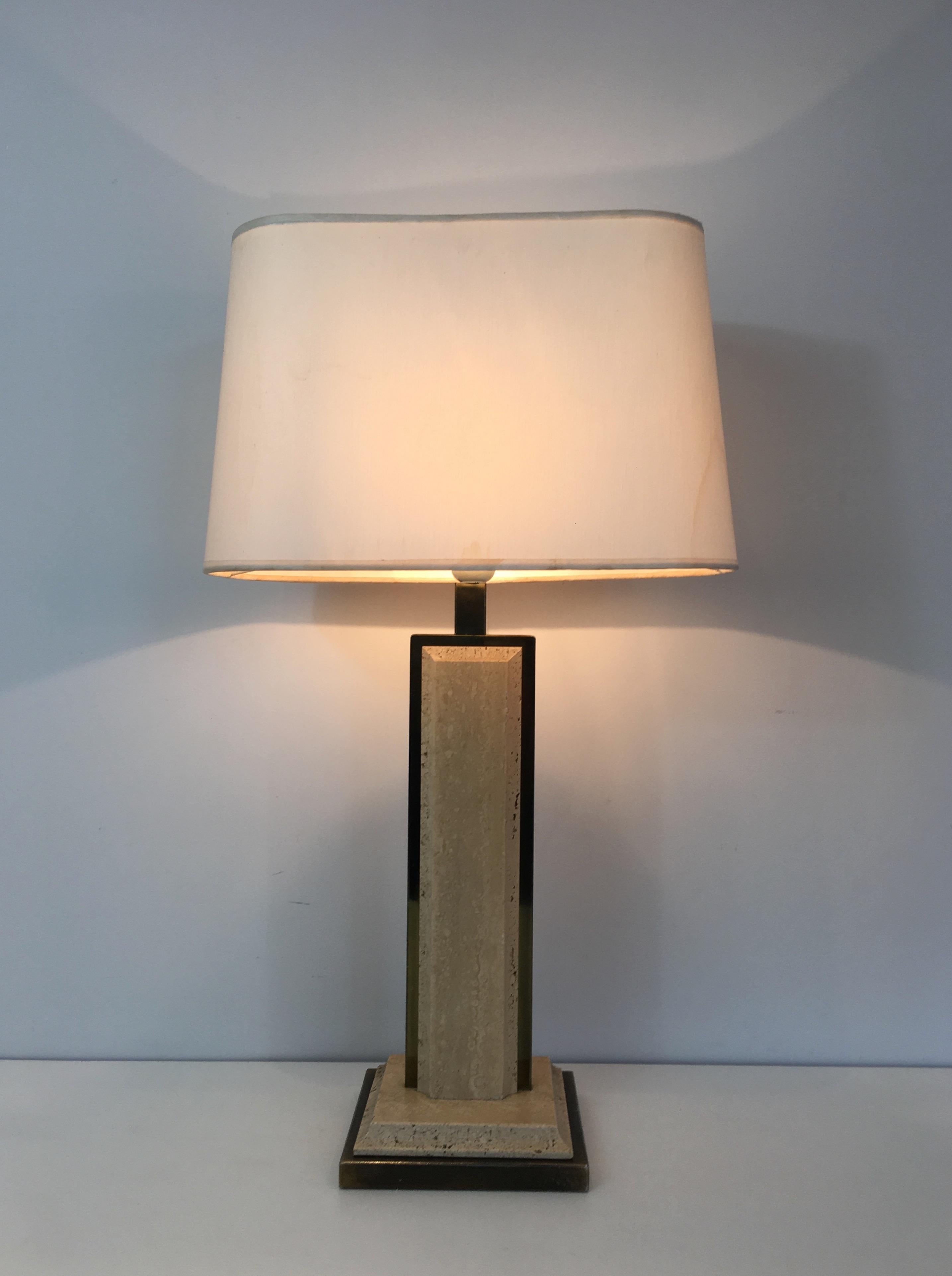 Cette très belle lampe de table est fabriquée en travertin et en métal doré. L'abat-jour est d'origine et un peu taché, la lampe est donc vendue avec un nouvel abat-jour personnalisé de la couleur de votre choix. Il s'agit d'un ouvrage français.