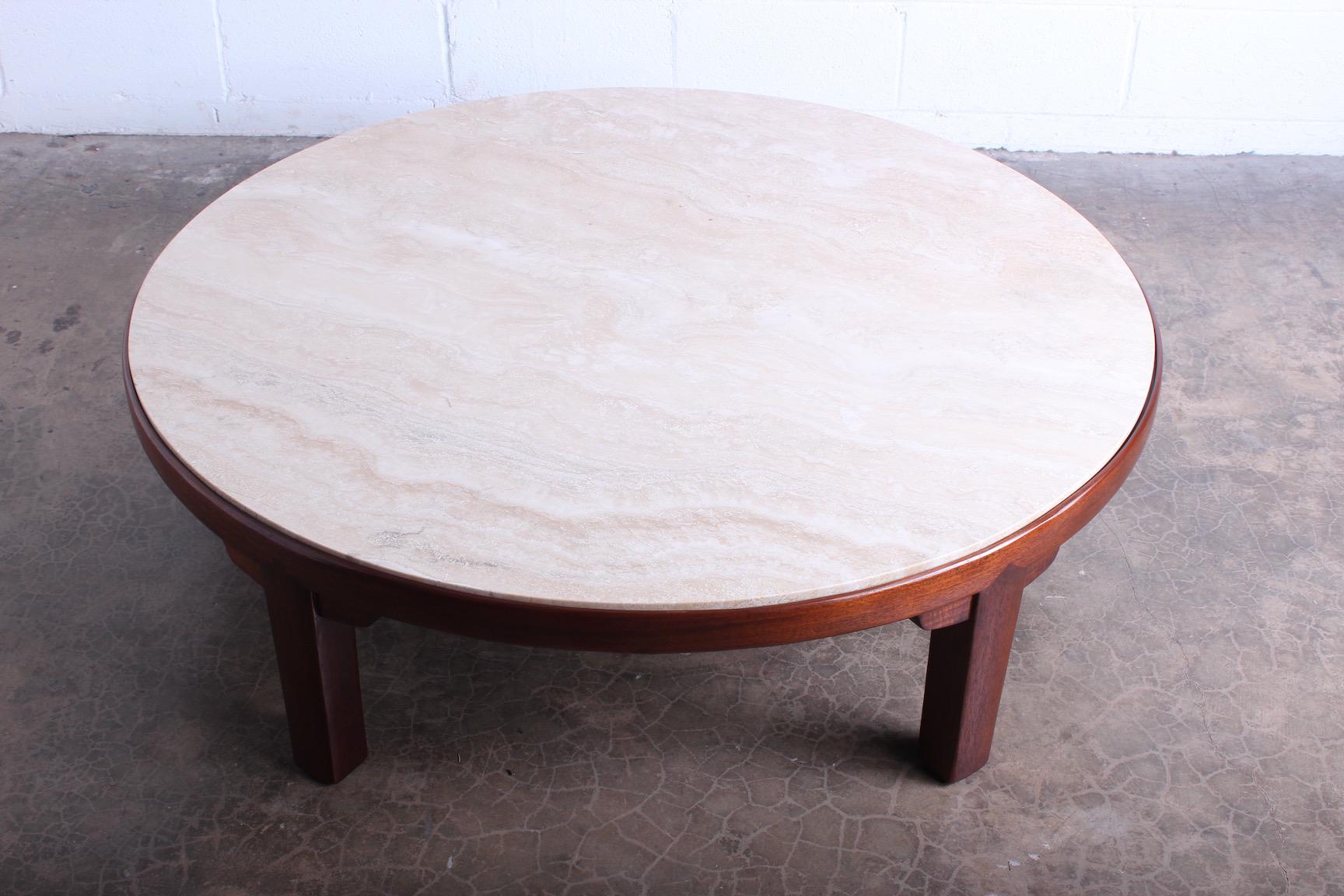 A mahogany coffee table with inset travertine top. Designed by Edward Wormley for Dunbar.