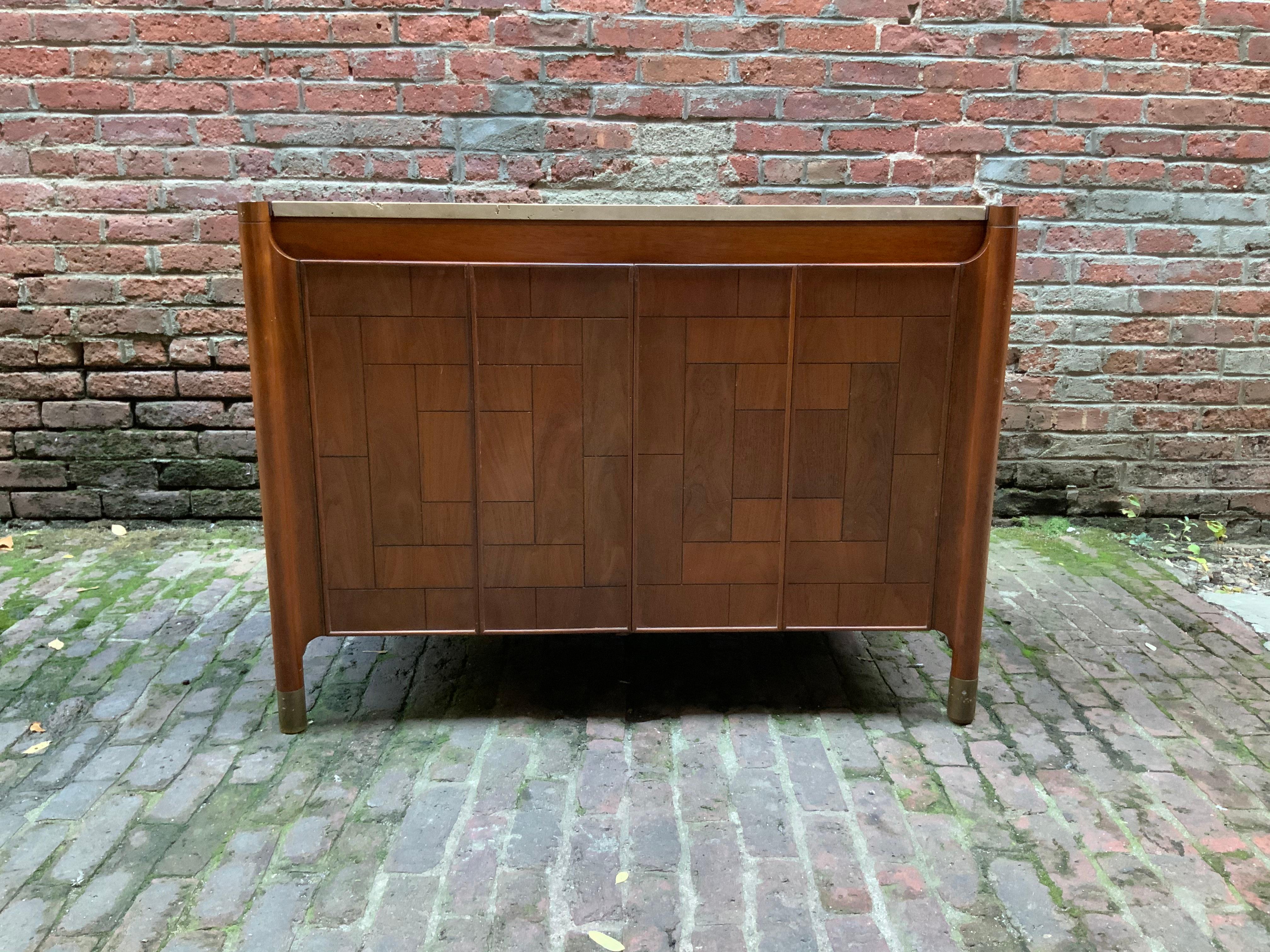 Patchwork two door cabinet with Travertine top. Fine walnut exterior with interior shelf. Brass finish sabots and finished back. This can be used anywhere in the home or office. Burn in mark on the reverse of the right door, Heritage, circa