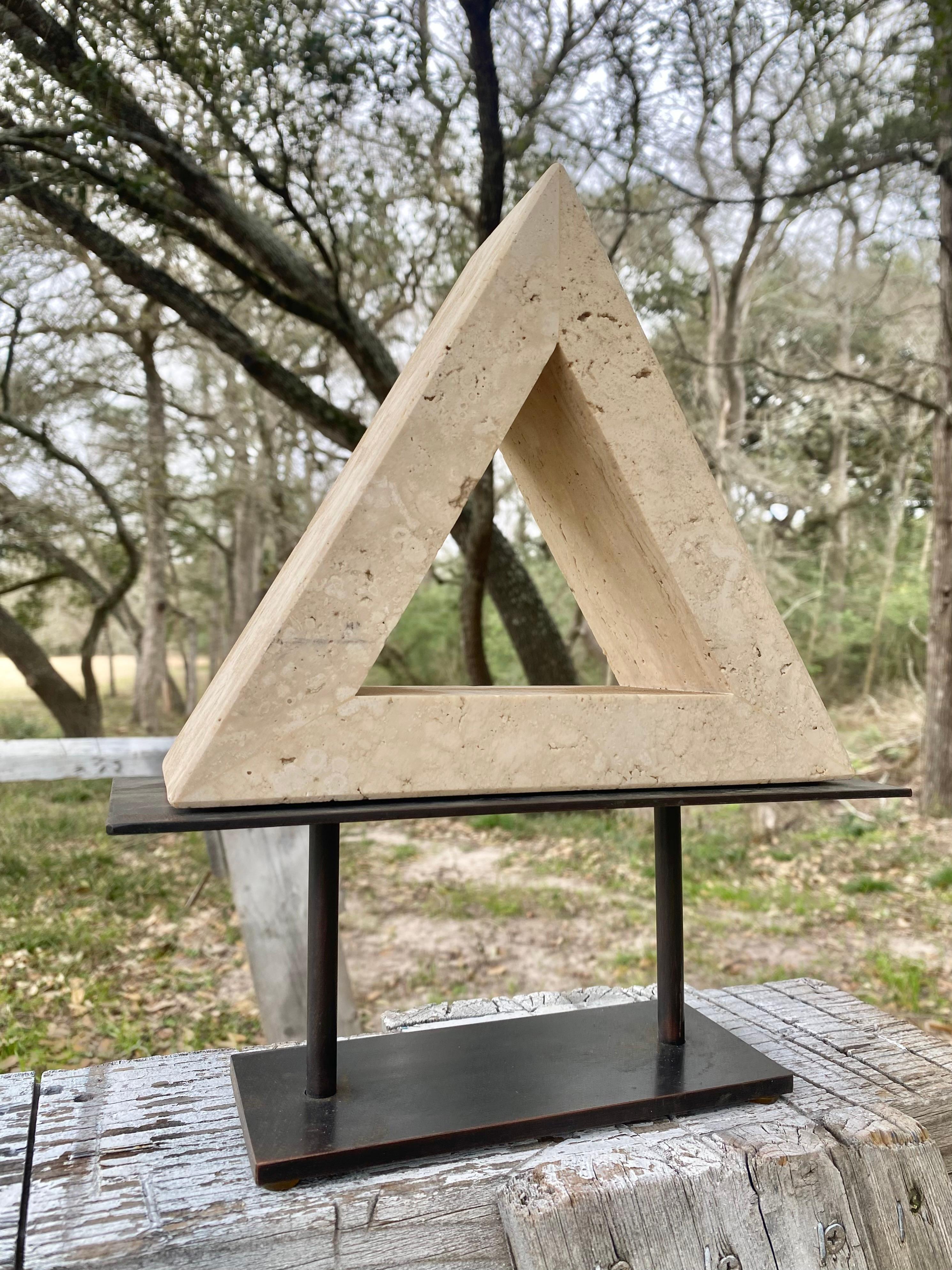 Imagine the sleek, geometric lines of the triangular travertine bookend, the natural stone, with its subtle, earthy hues and characteristic pitted texture, understated elegance. Attributed to the renowned Fratelli Mannelli for Raymor, this piece