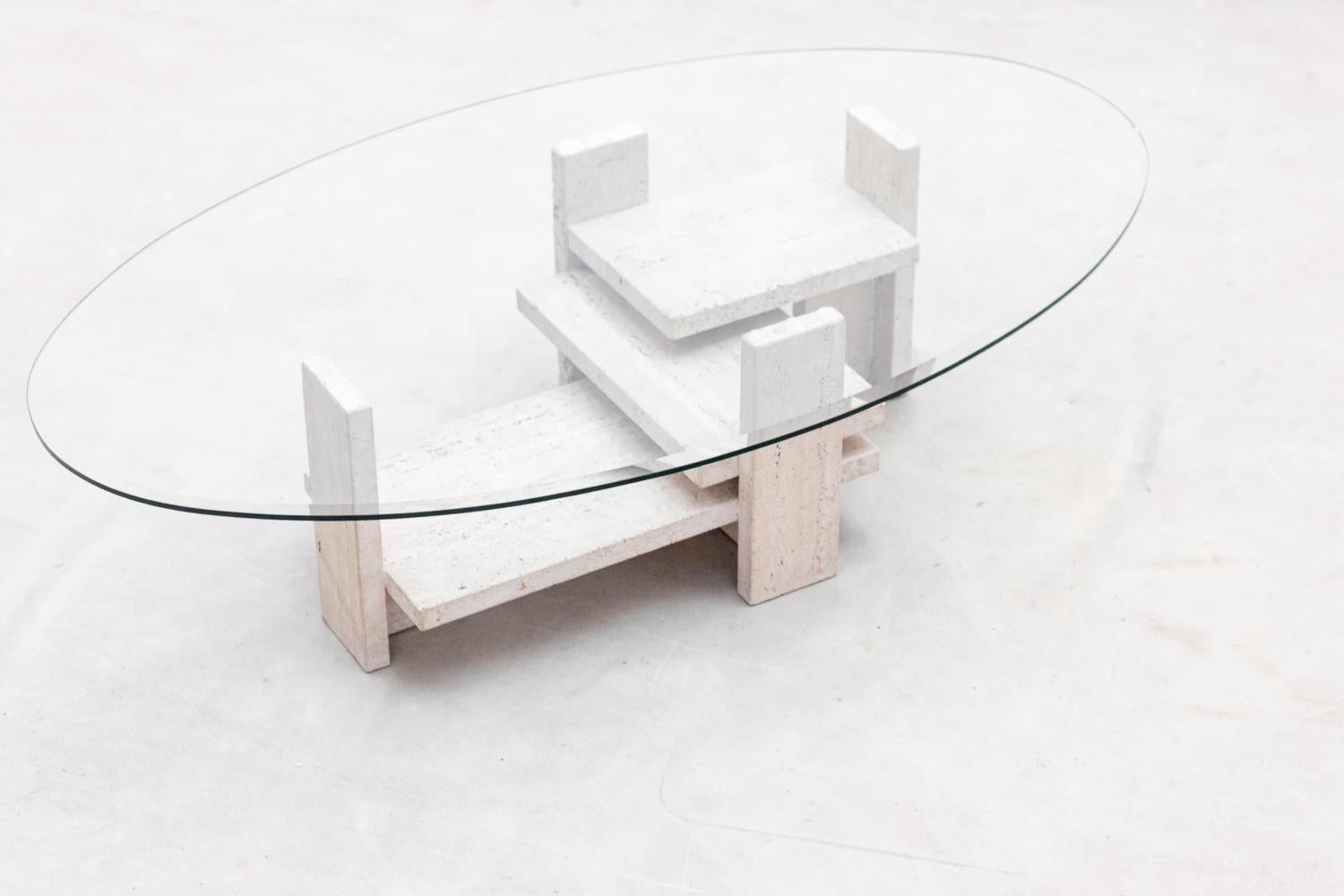 Table basse avec une base architecturale en travertin conçue par le designer belge Willy Ballez dans les années 70. 
La base en travertin est en très bon état. 
Le plateau en verre a un éclat sur le bord ( voir photo), nous pouvons remplacer le
