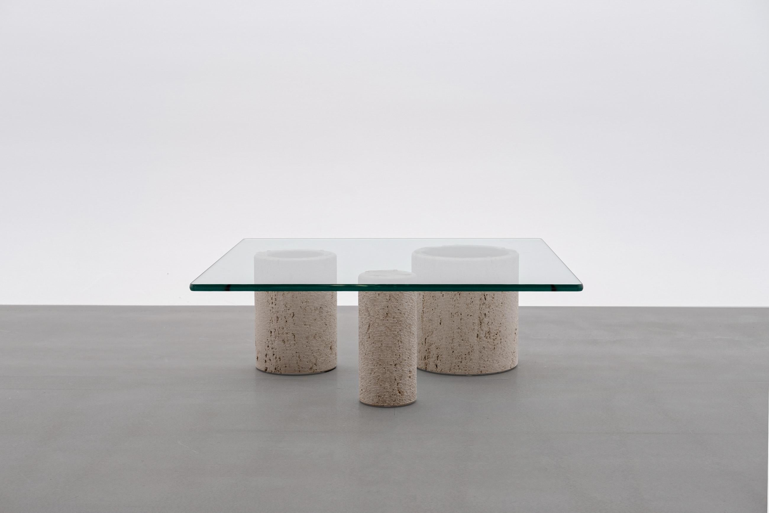 Travertine coffee table by Massimo Vignelli for Casigliani, Italy 1970s. Composed of three refined travertine columns of whom each vary in diameter and a 19 mm thick glass top. The surface of the columns have a rough cylindrical line structure,