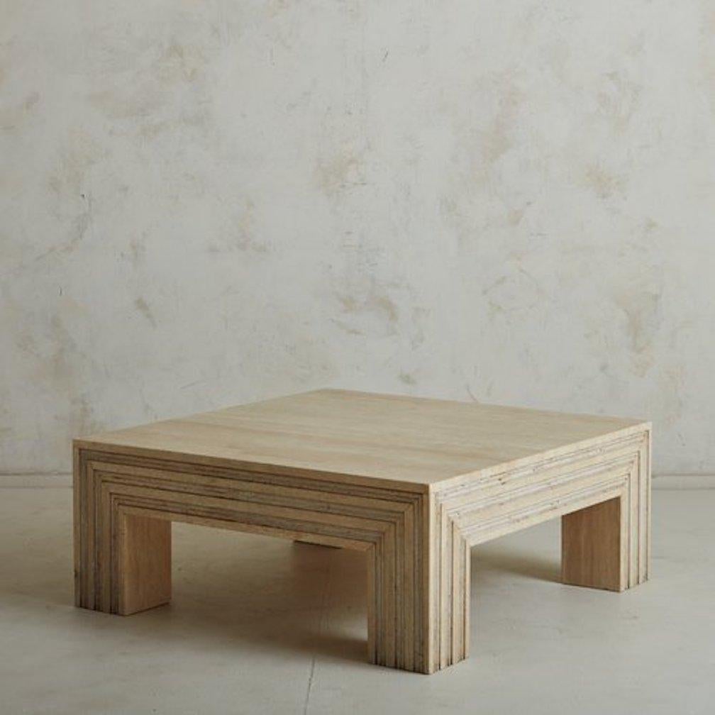 Une table basse espagnole vintage construite avec du travertin magnifiquement veiné. Cette table a un plateau carré et repose sur des pieds en bloc. Elle présente des détails sculptés le long des côtés et des pieds de la table. Provenance : Espagne,