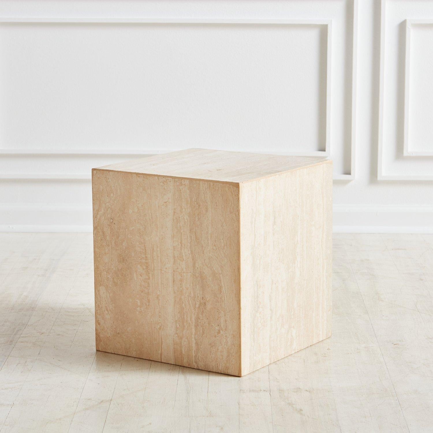 A postmodern cube side table constructed using five square honed travertine slabs featuring subtle, painterly veining. This table can sit directly on the ground or on a wooden plinth base with a brass laminate clad base. The minimal design of this