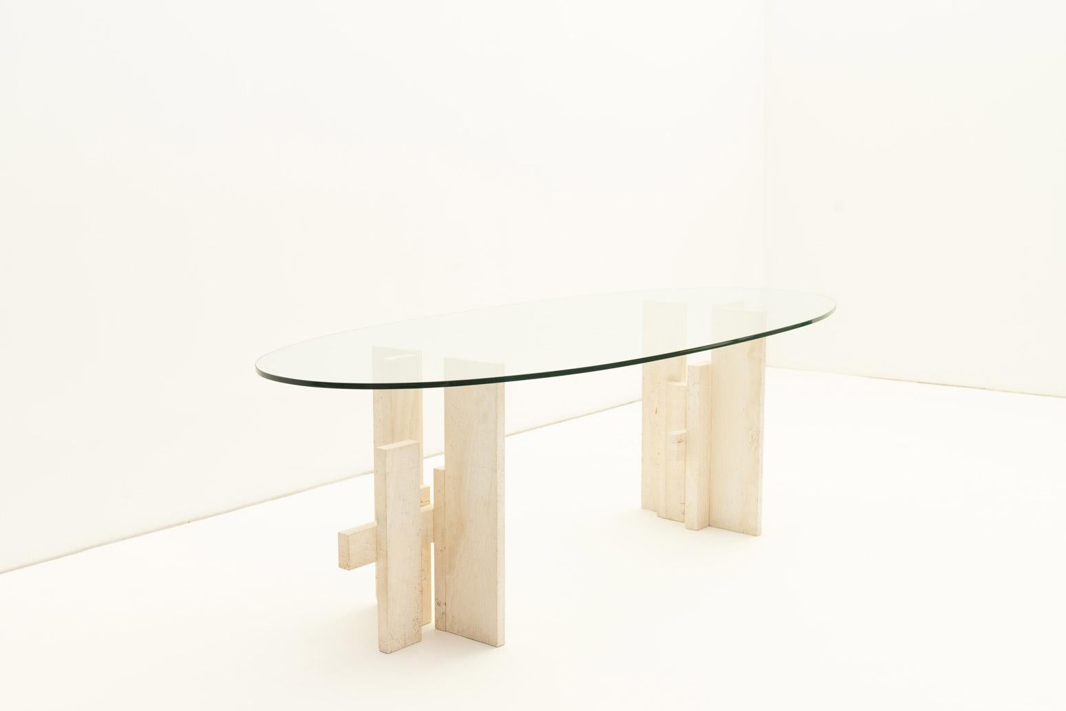 Cette table de salle à manger de Willy Ballez présente une base en travertin et un plateau en verre, mêlant matériaux naturels et design moderne.

Le socle en travertin a une forme sculpturale, offrant une base solide. Le plateau en verre permet de