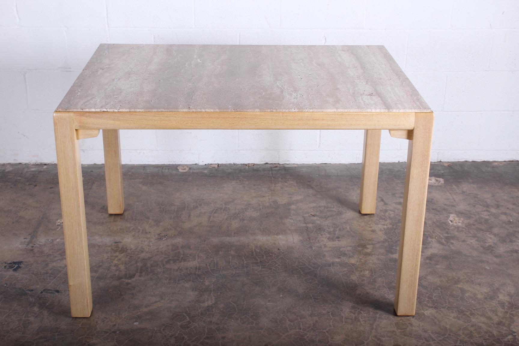 An early bleached mahogany and travertine table / desk designed by Edward Wormley for Dunbar.