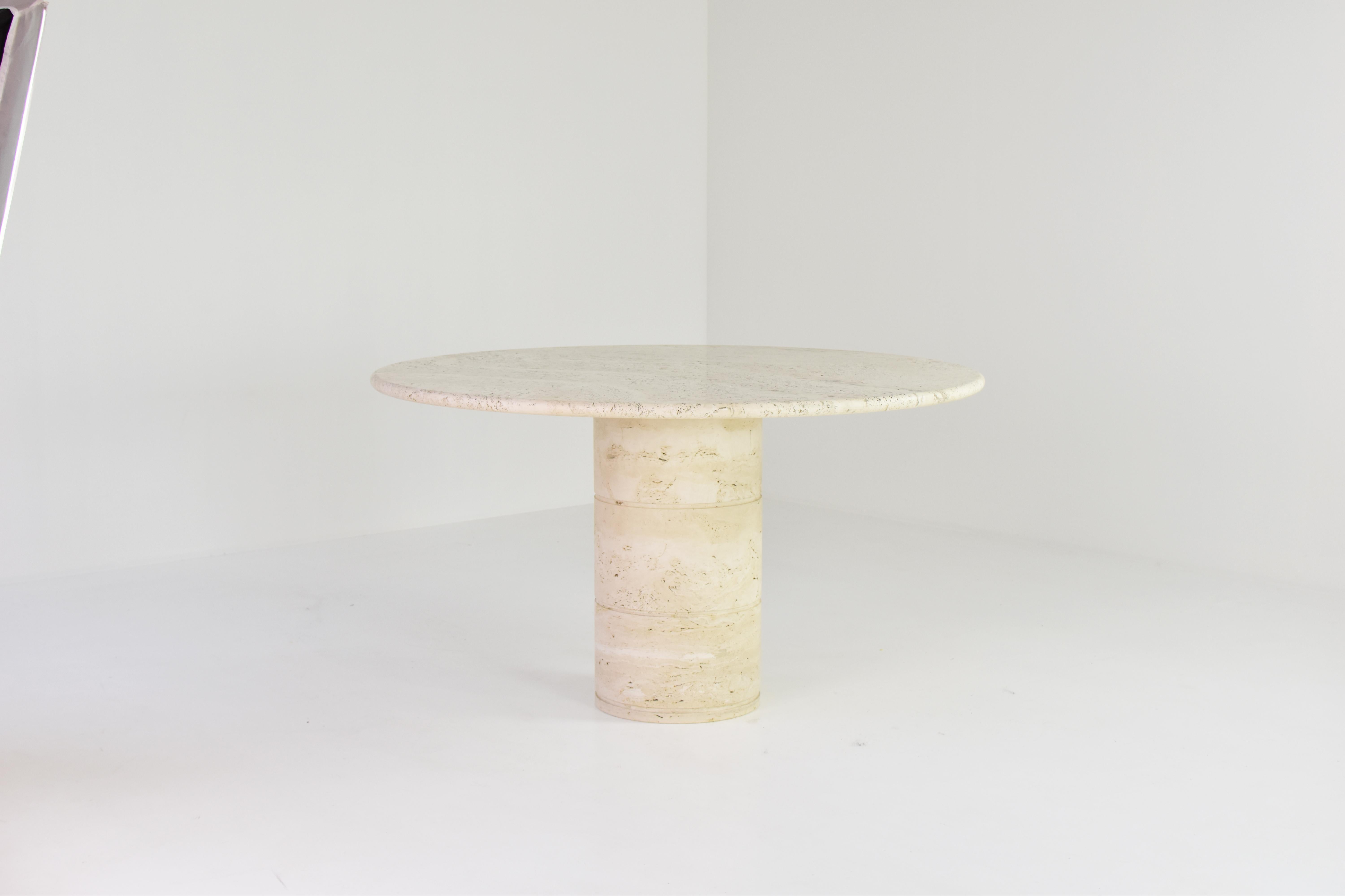 Stunning travertine dining table, Italy, 1970s. The table is fully made out of travertine with variegated tones of beige and brown. The top rests on a unique cylinder shaped pedestal base. Extremely good original condition!