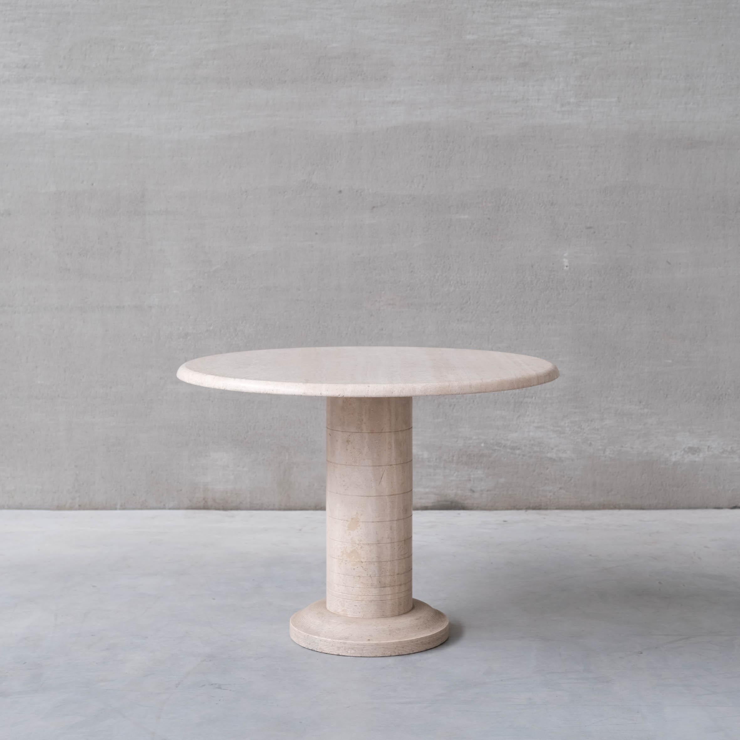 A heavy circular travertine dining table.

Italy, c1970s. 

The base is solid travertine segmented rings to the base.

The top remains in good condition generally, there are a few nicks and nibbles to the underside commensurate with