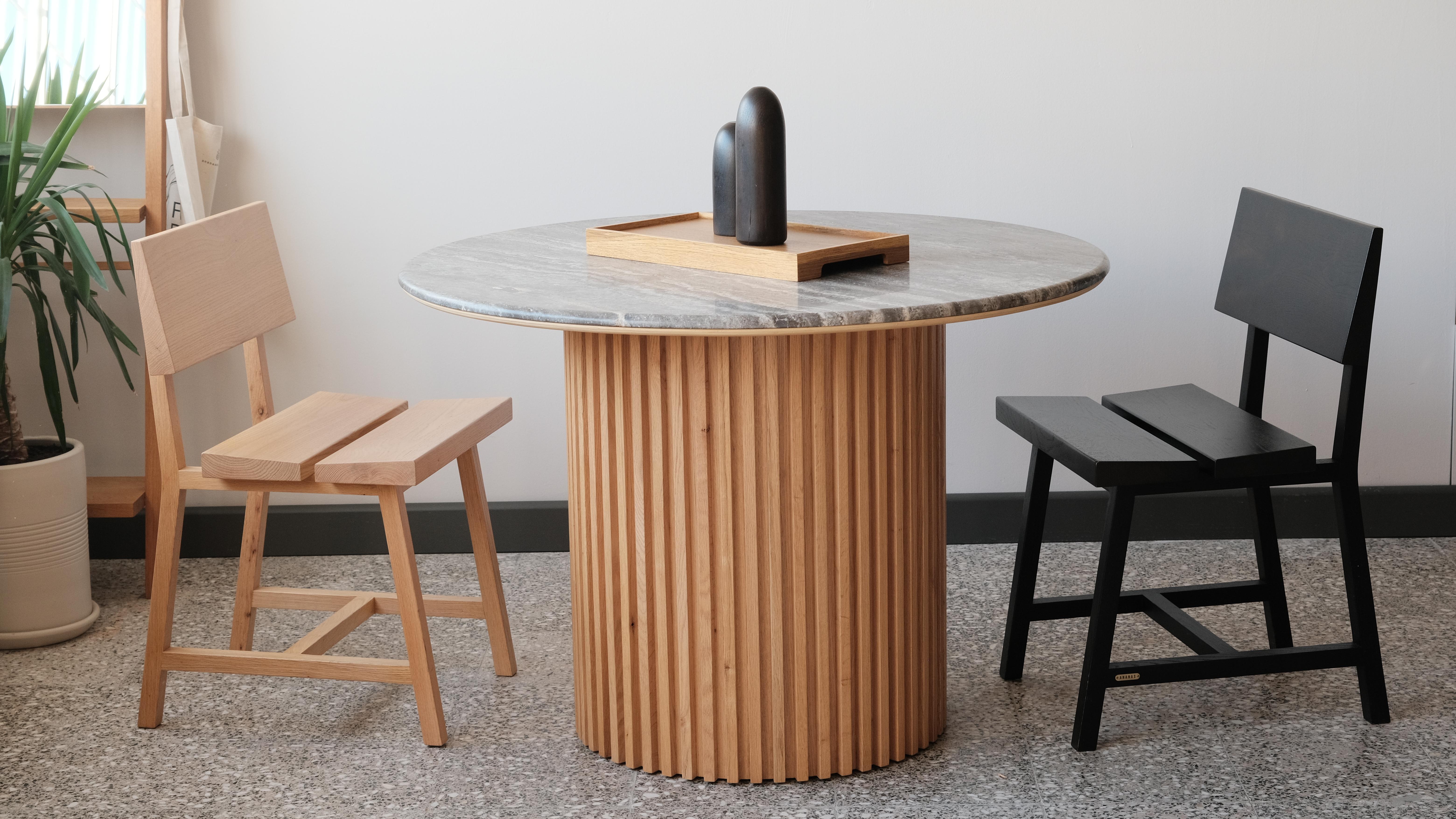 La table de salle à manger en marbre travertin de la série DOCIA est une table intemporelle qui associe des matériaux naturels à un design moderne. Le plateau de la table en travertin présente les motifs uniques du marbre naturel, tandis que ses