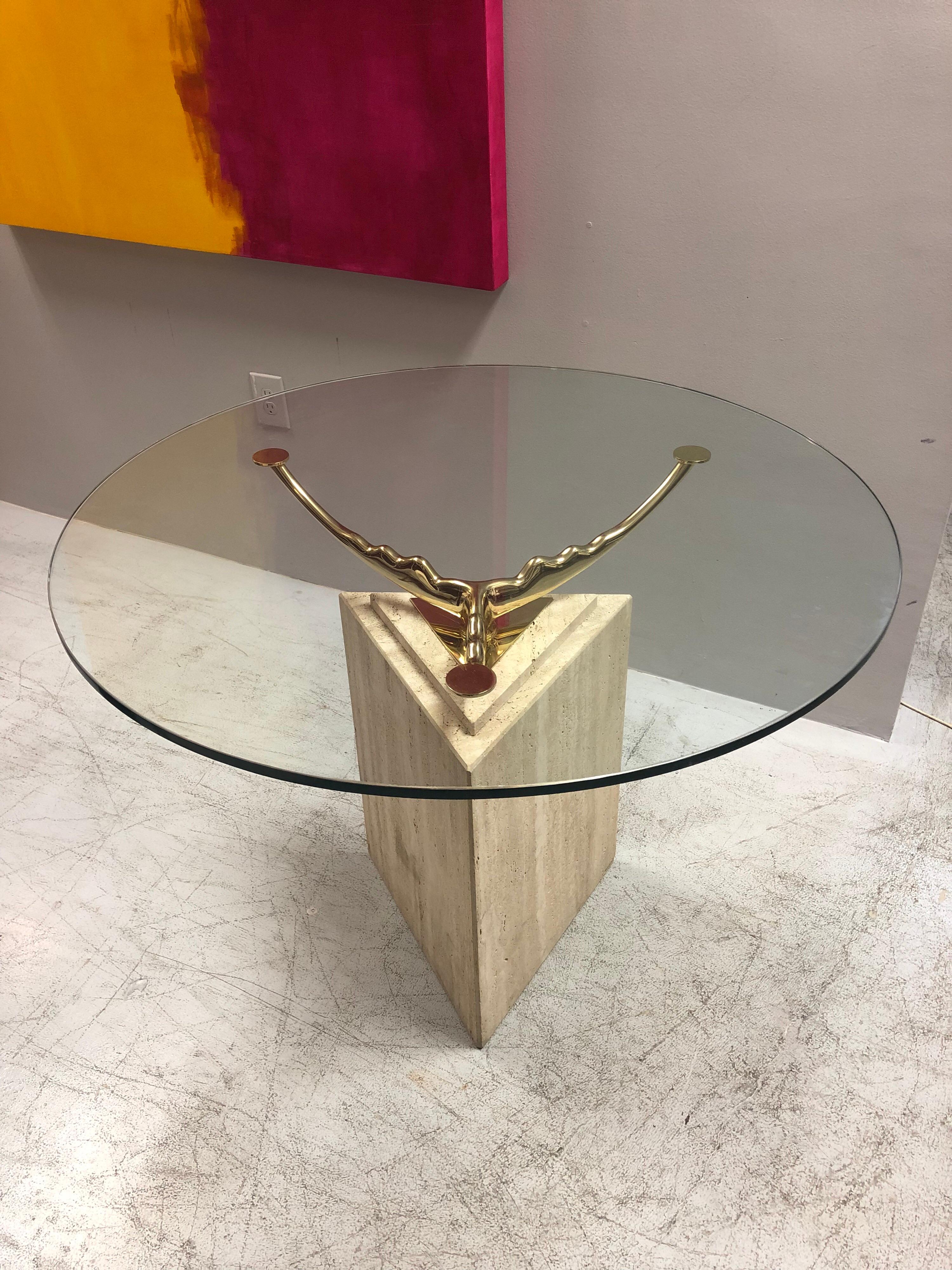 A geometric travertine base serves as a base for a 3-arm solid brass element that holds the glass top. Presented with a 39