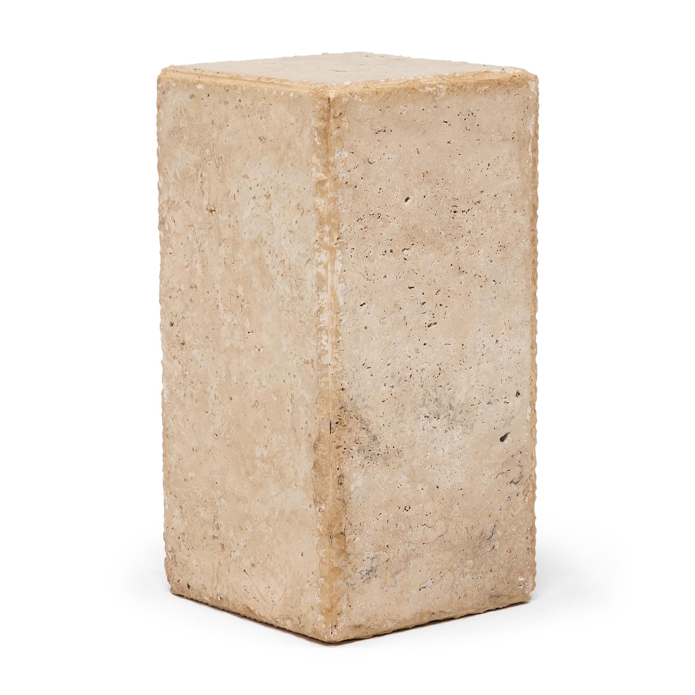 This minimalist block-form pedestal is hand-carved of solid travertine marble by a local Chicago artisan. Shaped with clean lines and balanced proportions, the narrow display stand exemplifies Organic Modern style with chiseled edges, smoothed sides