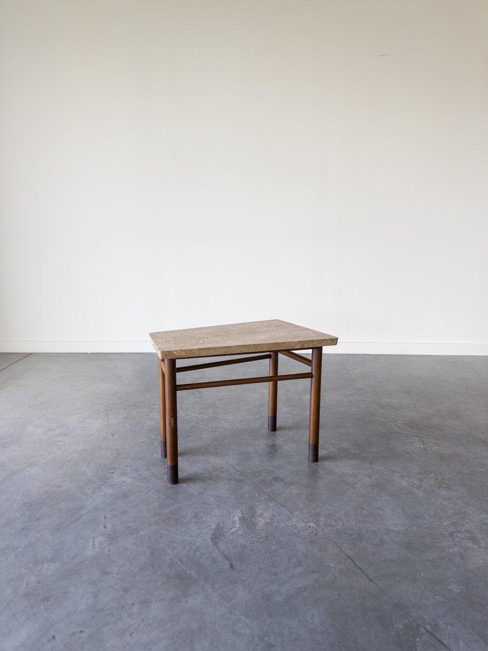 Edward Wormley For Dunbar Travertine End Table With A Wedge-shaped Beige Travertine Top On A Wooden Base With Connecting Stretchers And Four Dowel Legs Ending In Black Leather-wrapped Feet.