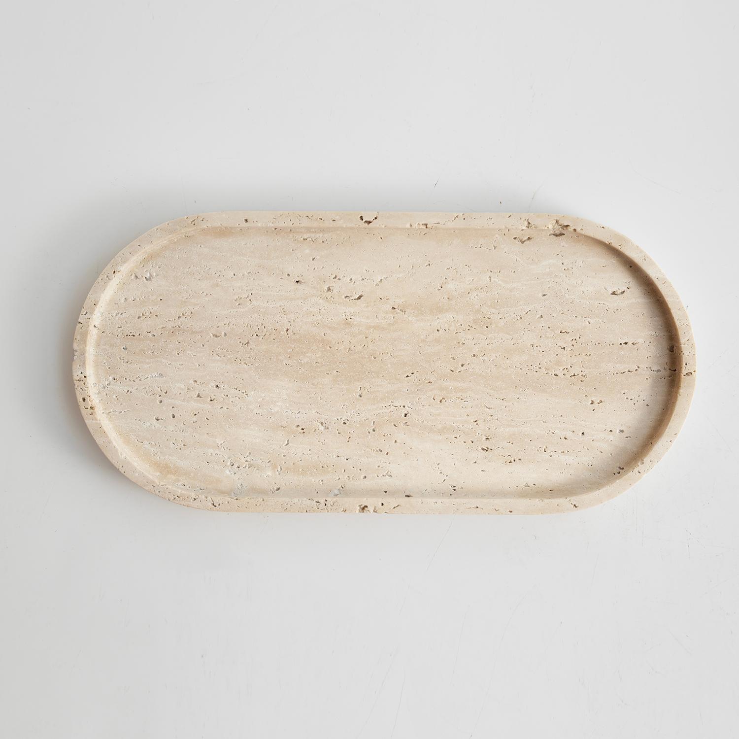 Elevate your space with the timeless elegance of the Travertine Oval Tray. Crafted from exquisite travertine adorned with natural pits, this versatile tray adds a touch of sophistication to any setting.

Designed for multi-purpose use, it seamlessly